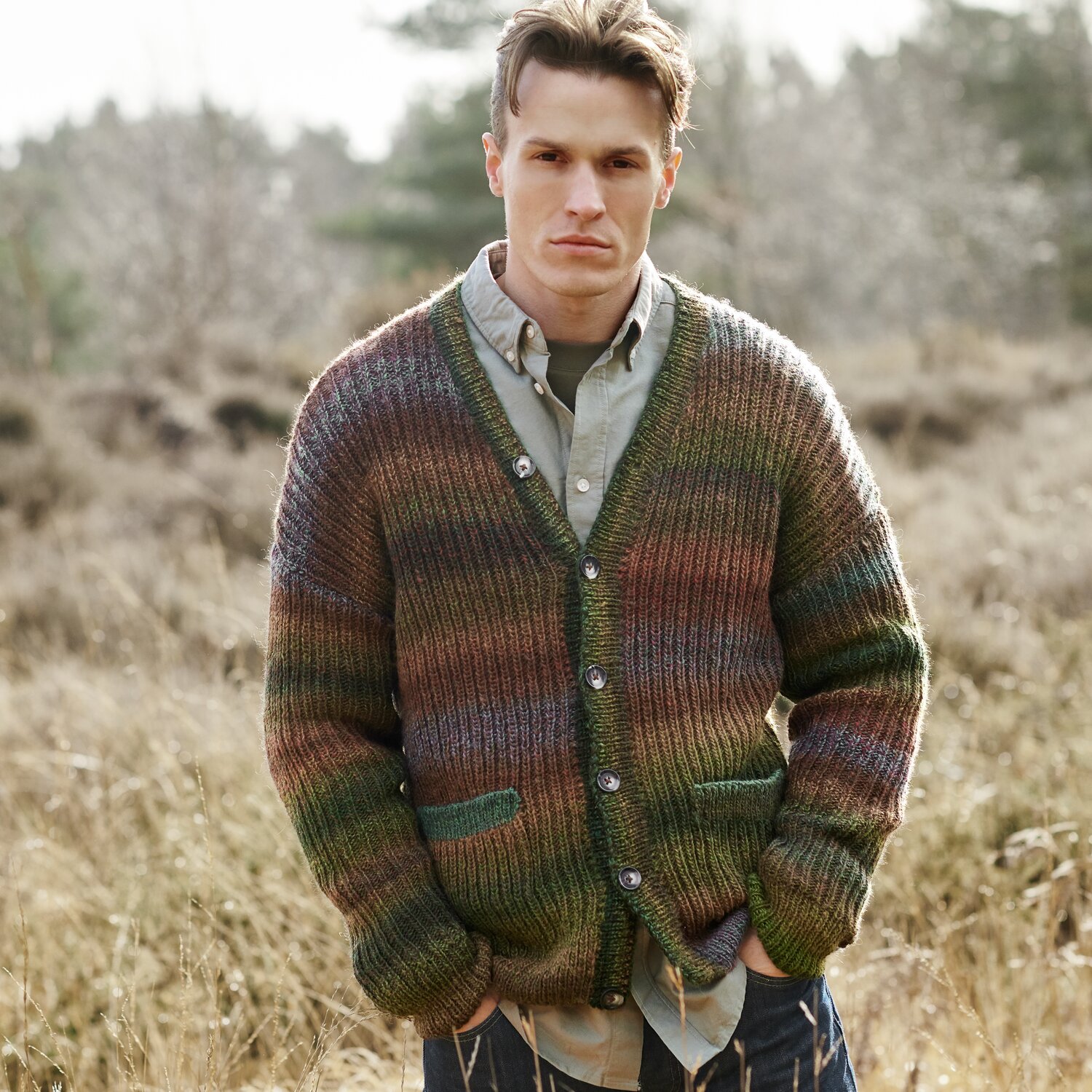Strickset Jacke Herren Modell 13 aus Lovewool No. 21 von Rico Design Strickset Jacke Herren Modell 13: Bunte Strickjacke aus Lovewool No. 21, getragen von einem Mann in natürlicher Umgebung.