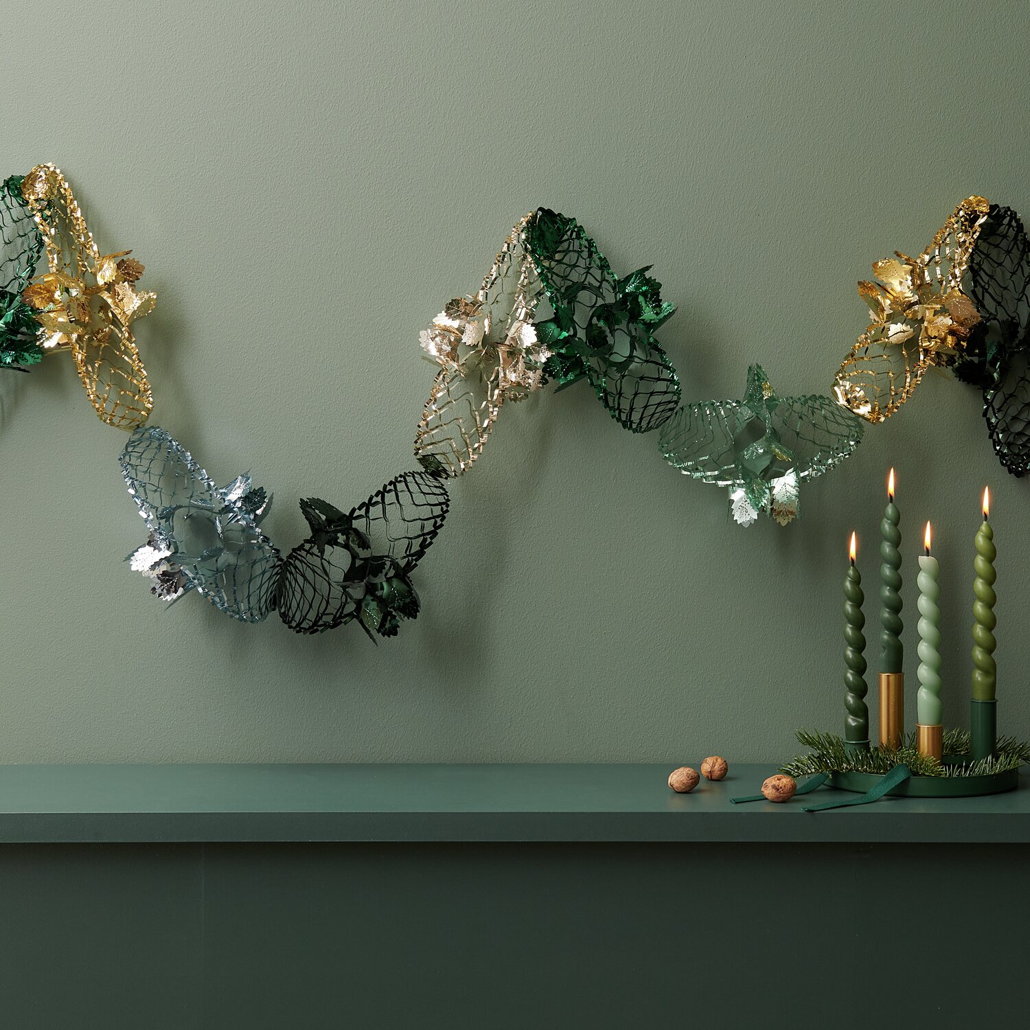 Foliengirlande von Rico Design in Mint und Gold, 2,3m lang, dekoriert mit Kerzen auf einem Tisch.