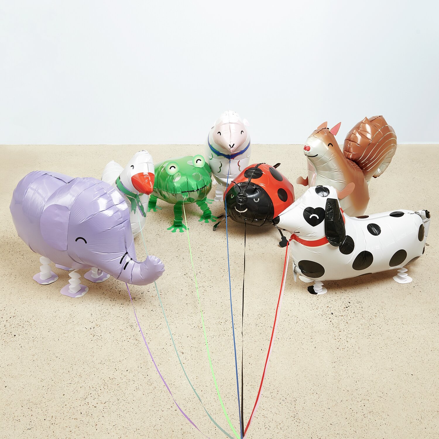 Folienballon Airwalker Elefant, Schaf, Frosch, Marienkäfer, Eichhörnchen und Dalmatiner in bunten Farben auf hellem Boden.