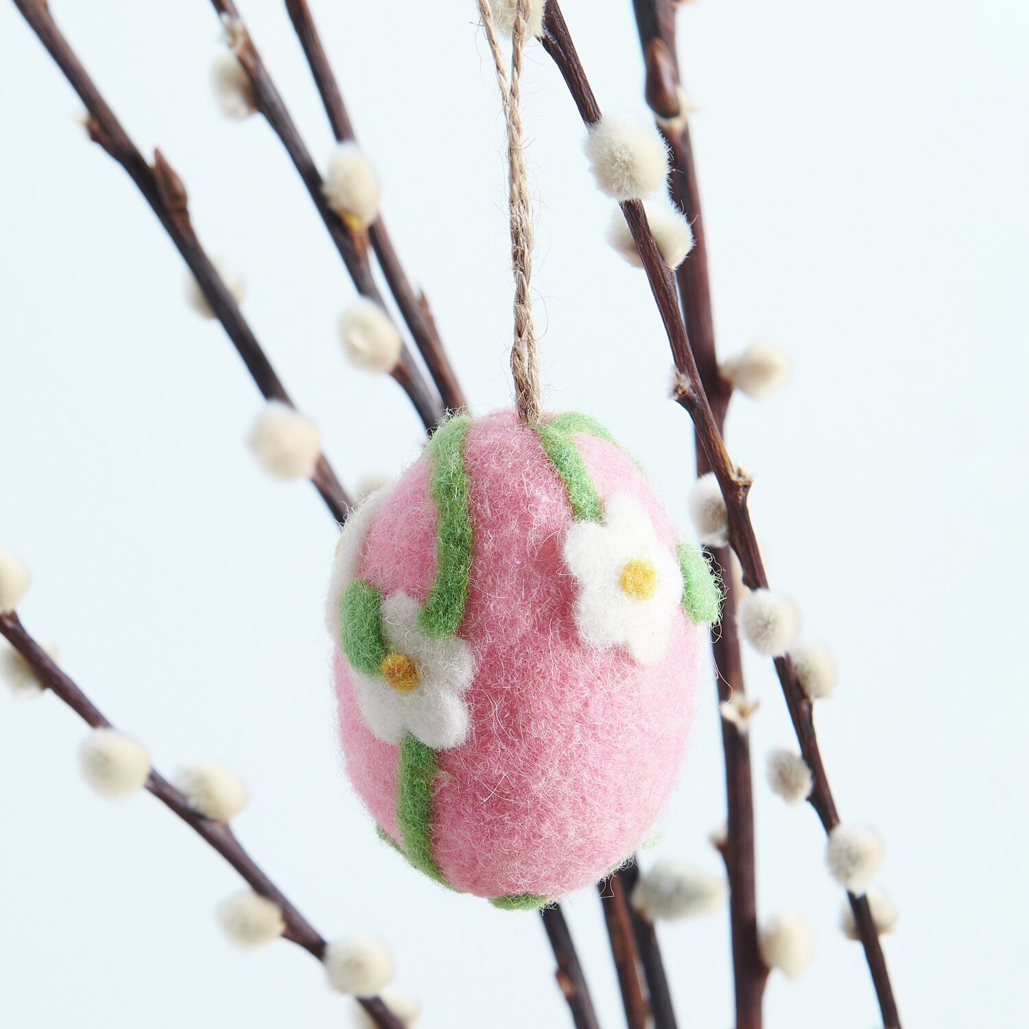 Aufhänger Filz-Ei Gänseblümchen: Rosa Filz-Ei mit weißen Blüten, dekorativ an Zweigen hängend. Größe: 7,8xØ5,8cm.