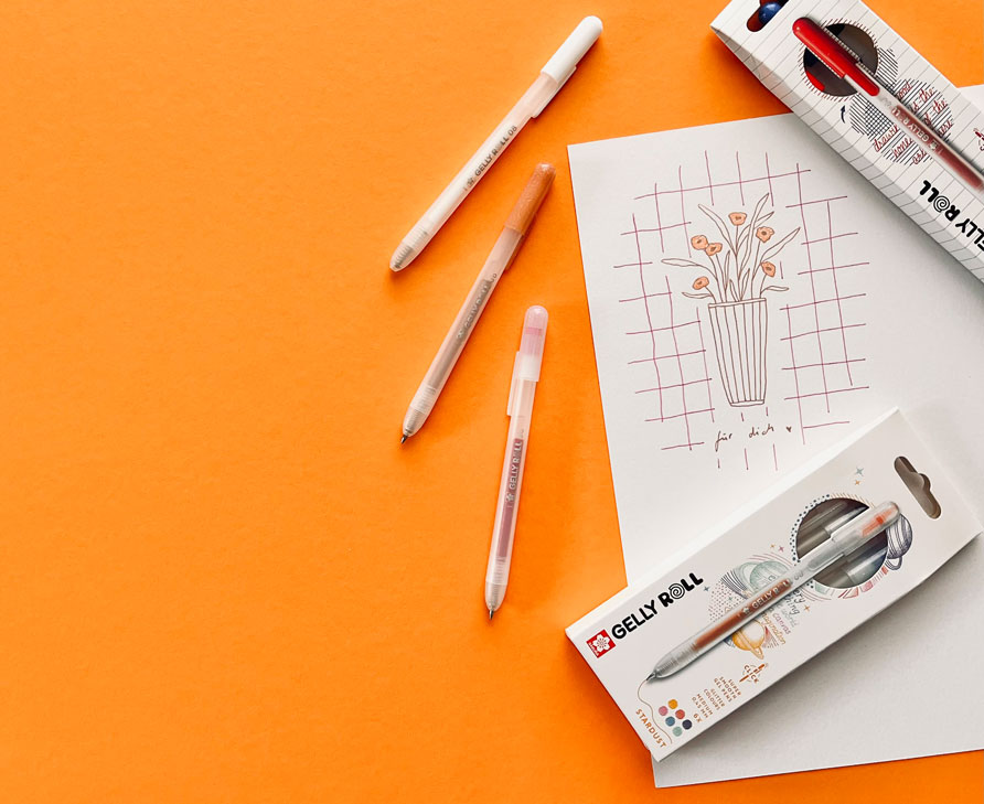 Gezeichnete Blumen in einer Vase mit einem Schriftzug, daneben drei Gelly-Roll-Stifte und Gelly-Roll-Stifte in der Verpackung. Flatlay von Produkten.