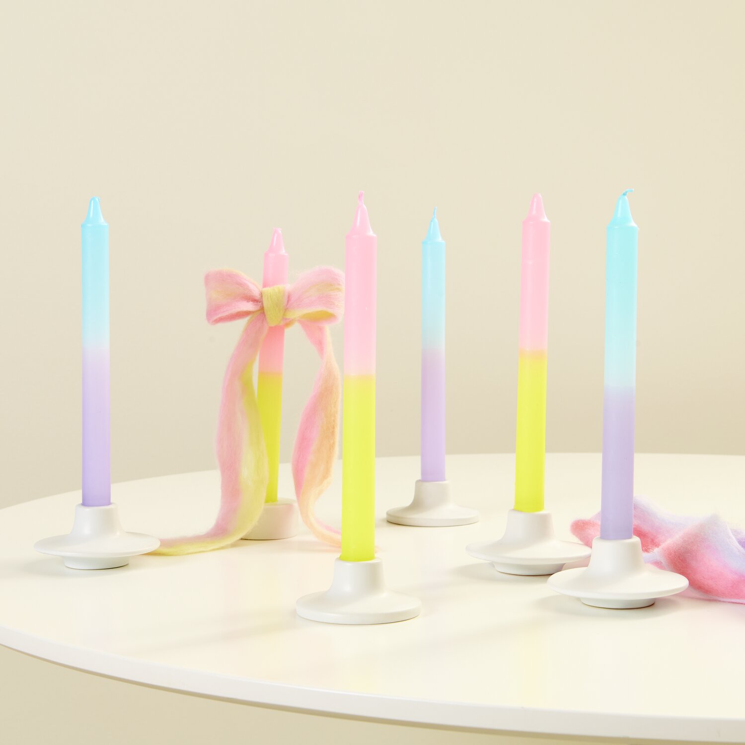 Kerze Dip Dye: Bunte Kerzen in Gelb-Rosa und Flieder-Blau von Rico Design auf weißem Tisch.