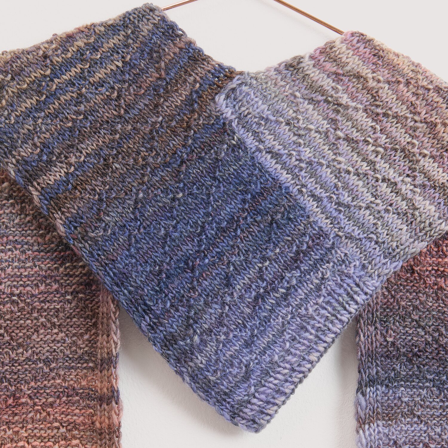Die Neue Masche No. 16 Herbst gestrickter Schal von Wolle Rödel in melierten Blau‑, Lila‑ und Brauntönen, weich strukturiert und locker über Bügel drapiert