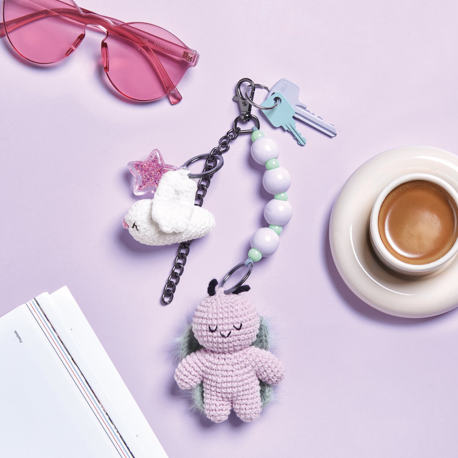 Ricorumi Häkelset Schlüsselanhänger - Chingu Sky: Lila gehäkelter Anhänger mit Perlen, Schlüssel und rosa Brille auf hellem Hintergrund.