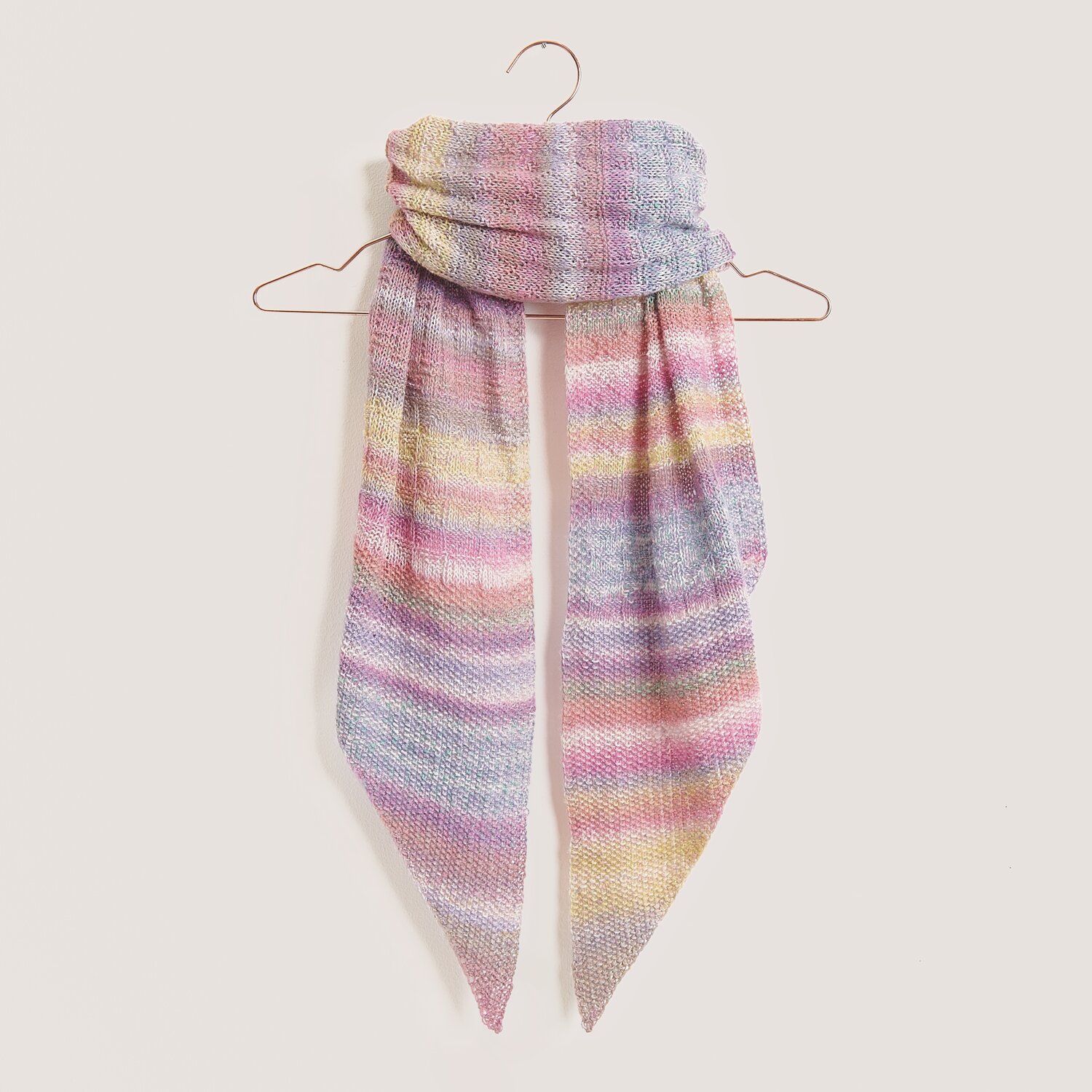 Strickset Tuch Modell 10 aus Tücher Special zeigt ein pastellfarbenes, gestreiftes Tuch aus Fashion Cotton Merino Lace auf einem Kleiderbügel.