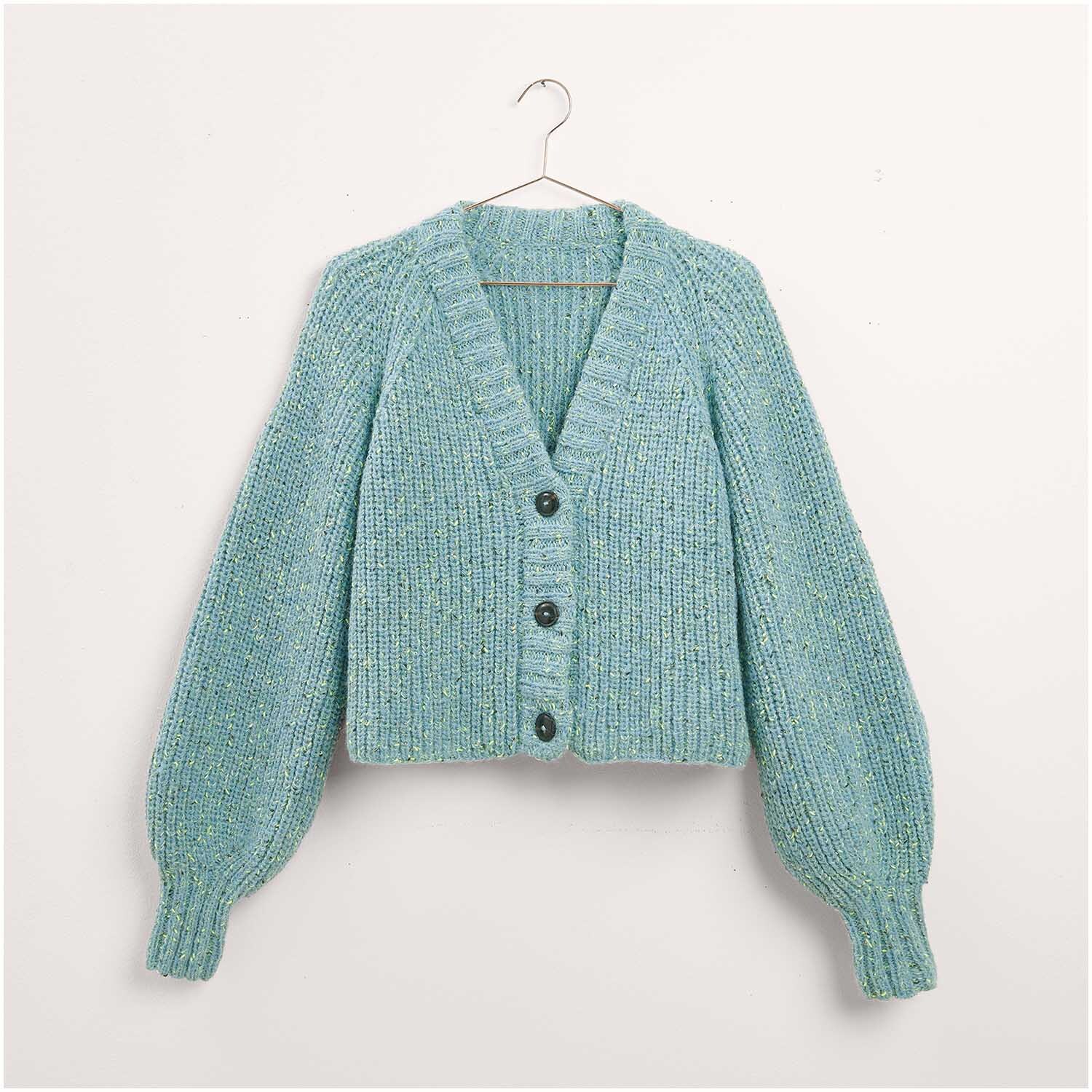 Strickjacke in sanftem Blau, präsentiert als Legeware. Teil des Stricksets Modell 20a aus "Made by Me Nr. 17". Die Jacke hat einen V-Ausschnitt und große Knöpfe. Ideal für DIY-Projekte.