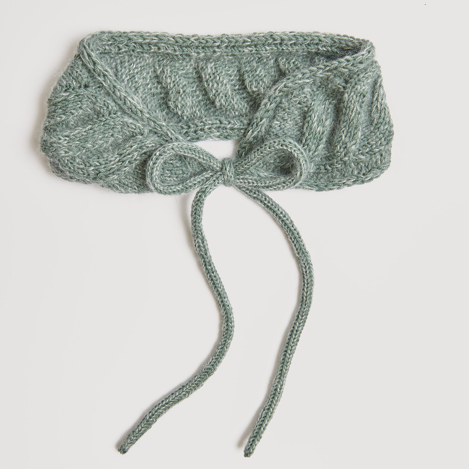 Die Neue Masche No. 13 Herbst von idee. Creativmarkt Essentials Merino dk: Eleganter, gestrickter Schal in Efeu-Grün mit dekorativer Schleife.