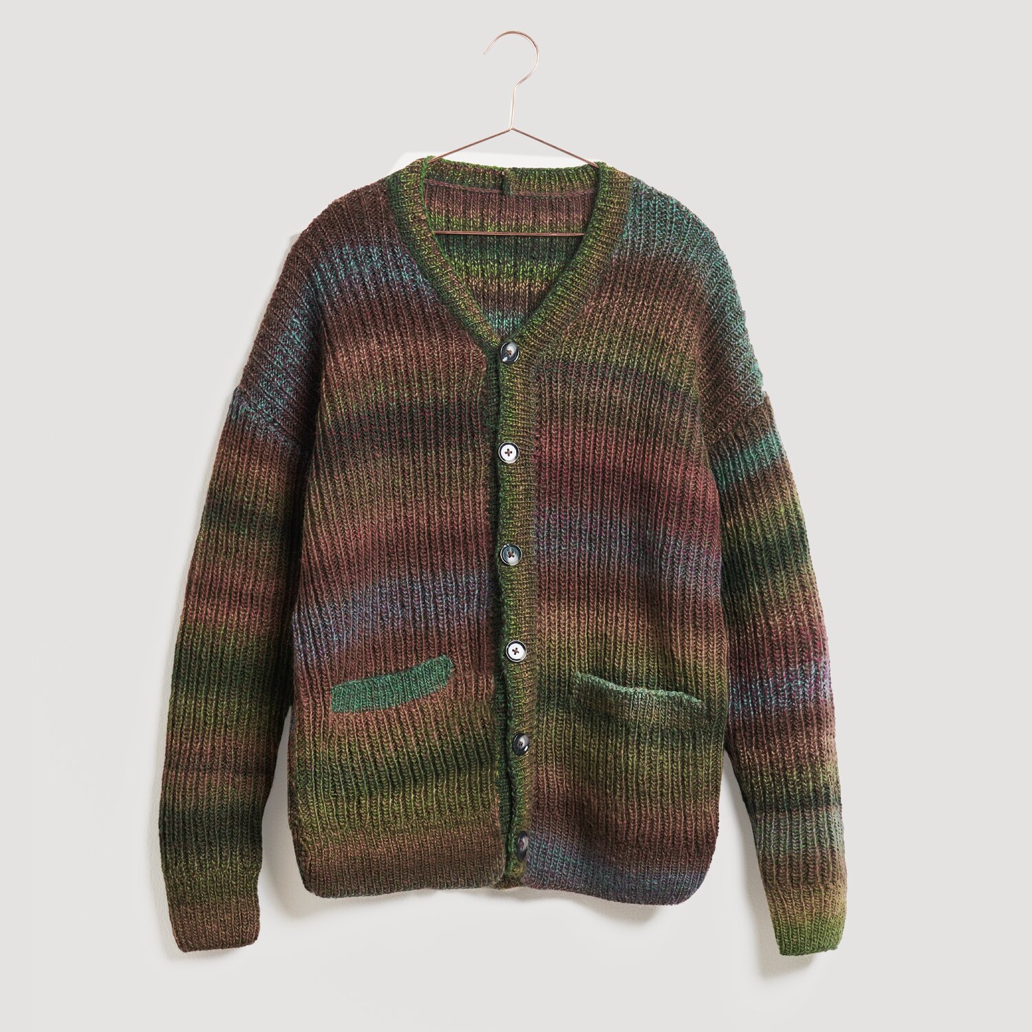 Lovewool No. 21 Herbst-Winter Sprachauswahl deutsch von Rico Design Strickjacke in Erdtönen, Modell Legeware. Die Jacke hat einen V-Ausschnitt, Knopfleiste und zwei Taschen. Ideal für kühle Tage, bietet sie Komfort und Stil.