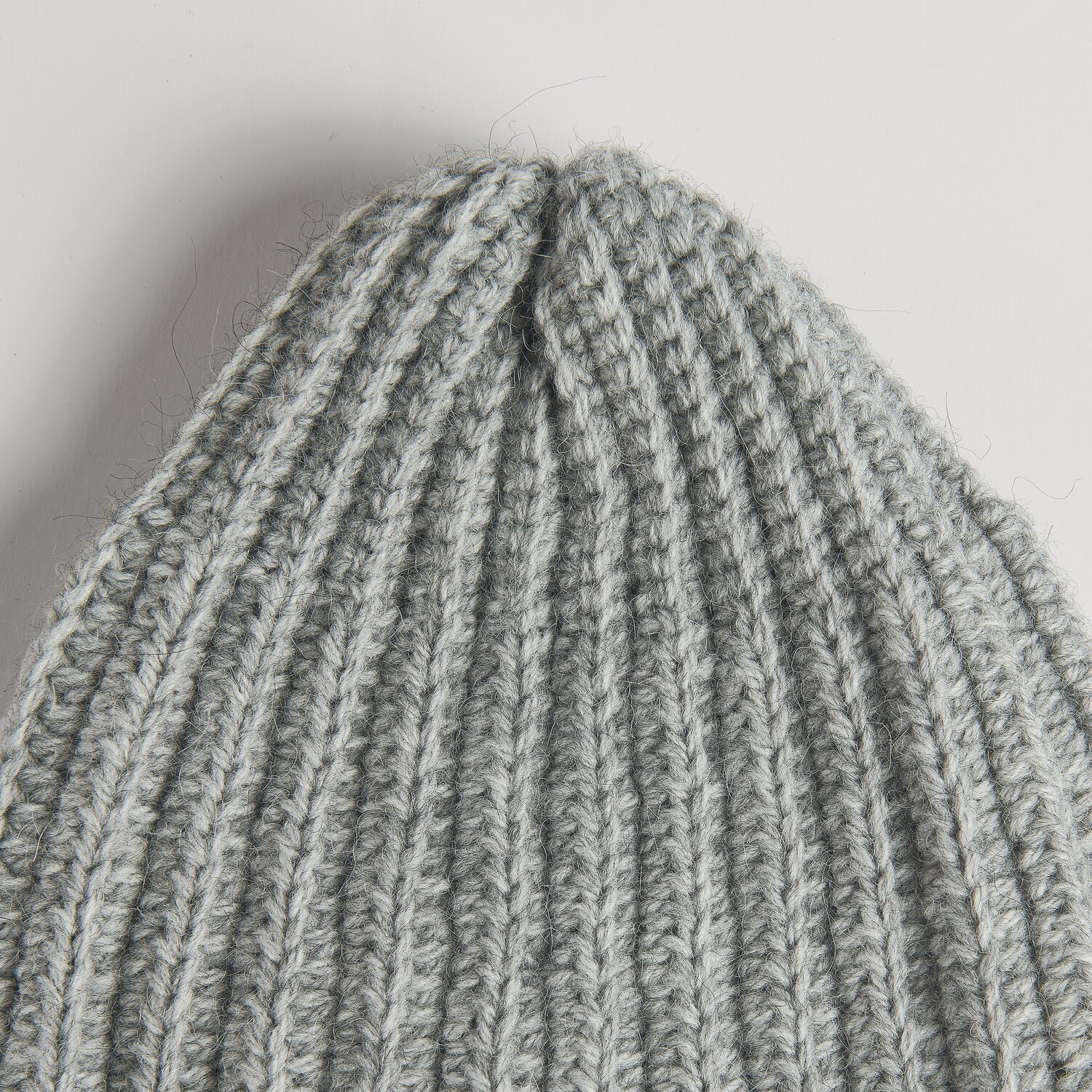 Die Neue Masche No. 16 Herbst gestrickte Mütze aus weicher Wolle Rödel in hellgrauer Rippstruktur, Detailansicht der formstabilen, spitz zulaufenden Spitze