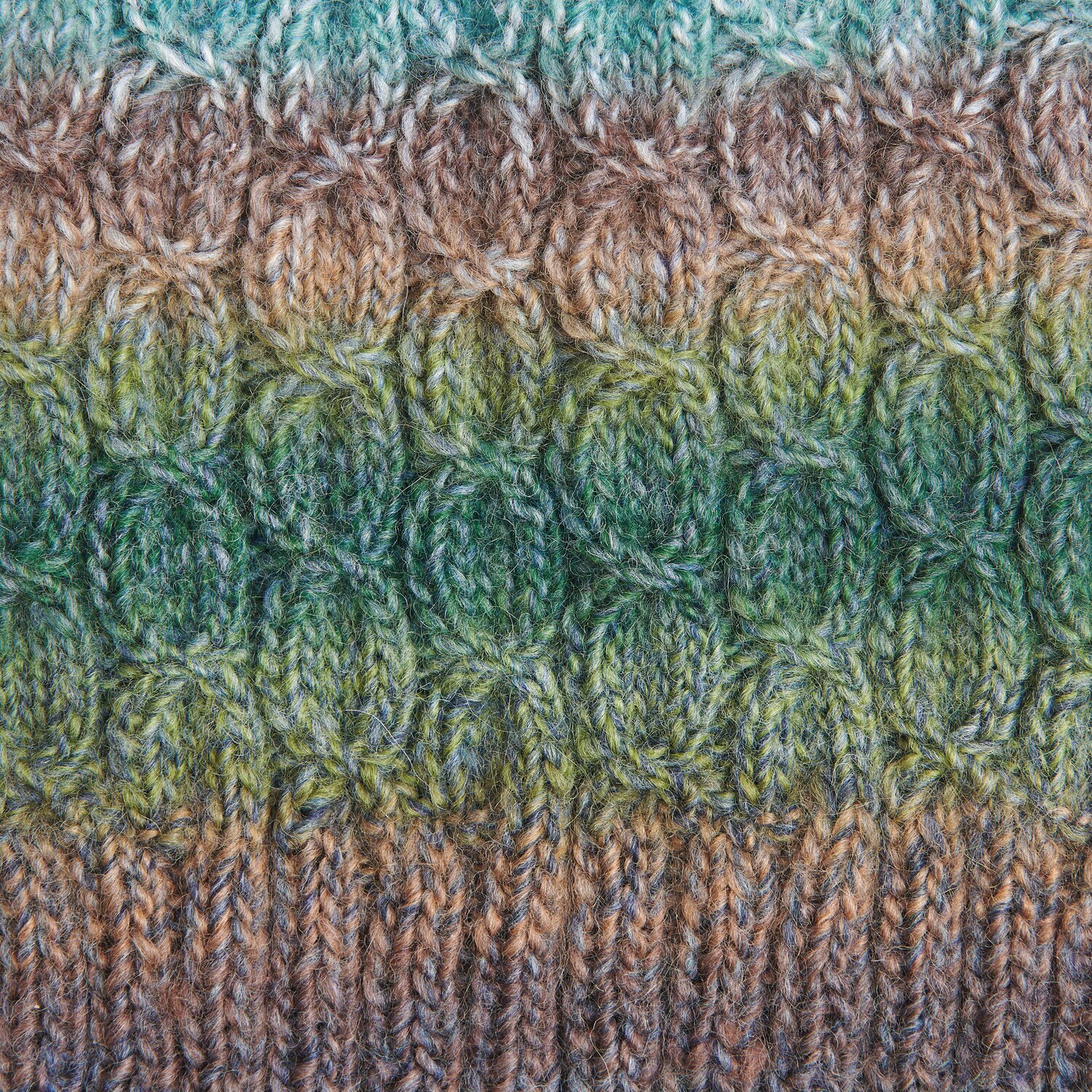 Die Neue Masche No. 13 Herbst von idee. Creativmarkt Creative Melange Alpaca Wonderball dk zeigt ein gestricktes Muster in Braun- und Grüntönen. Ideal für Herbstprojekte.