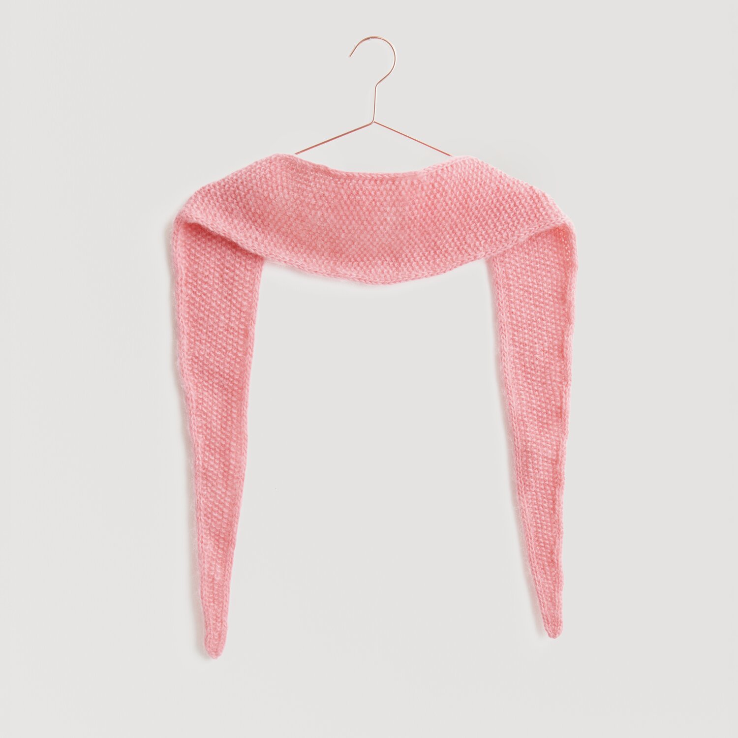 Lovewool No. 21 Herbst-Winter Sprachauswahl deutsch von Rico Design Ein weiches, rosa Strickschal von Modell Legeware hängt auf einem Kleiderbügel. Der Schal hat eine gleichmäßige Textur und ist ideal für kühle Tage. Perfekt für modische Akzente.