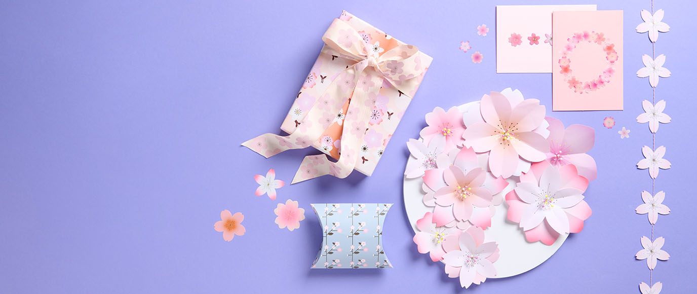 Geschenk und Karten mit Kirschblütendesign auf lila Hintergrund