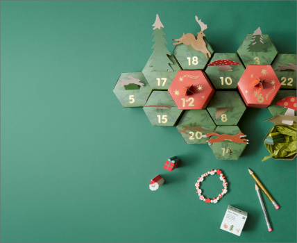 Geöffneter Adventskalender in Wabenform mit kleinen Überraschungen und Tiermotiven.