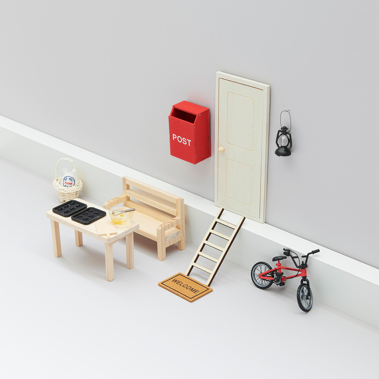 Hauseingang mit Sitzbank, Tisch, Eingangstür und Fahrrad in Miniaturform. Fotosetting graue Ecke.