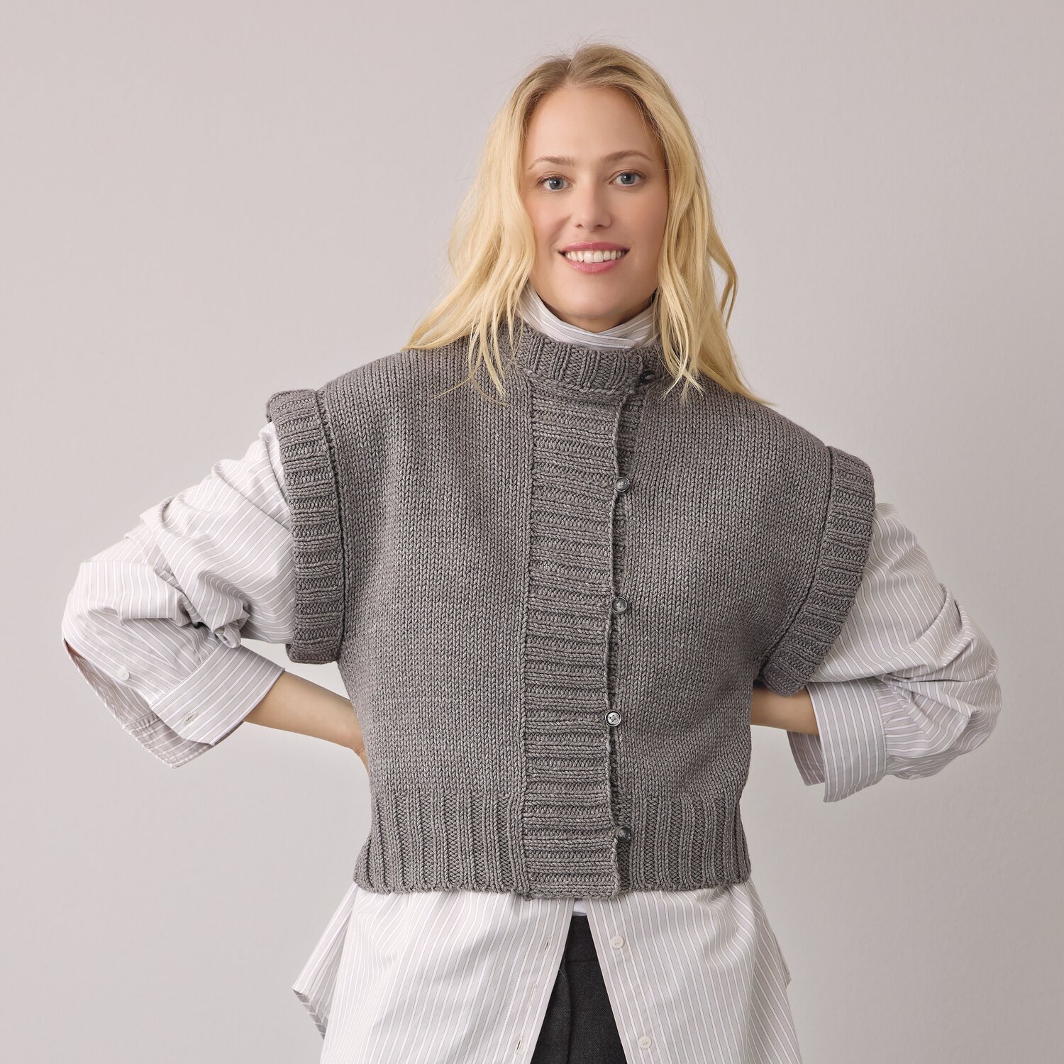 Strickset Weste Modell 24 aus Die Neue Masche No. 14 von idee. Creativmarkt Strickset Weste Modell 24 aus DNM 14, graue Weste über weißem Hemd, lässiger Look.