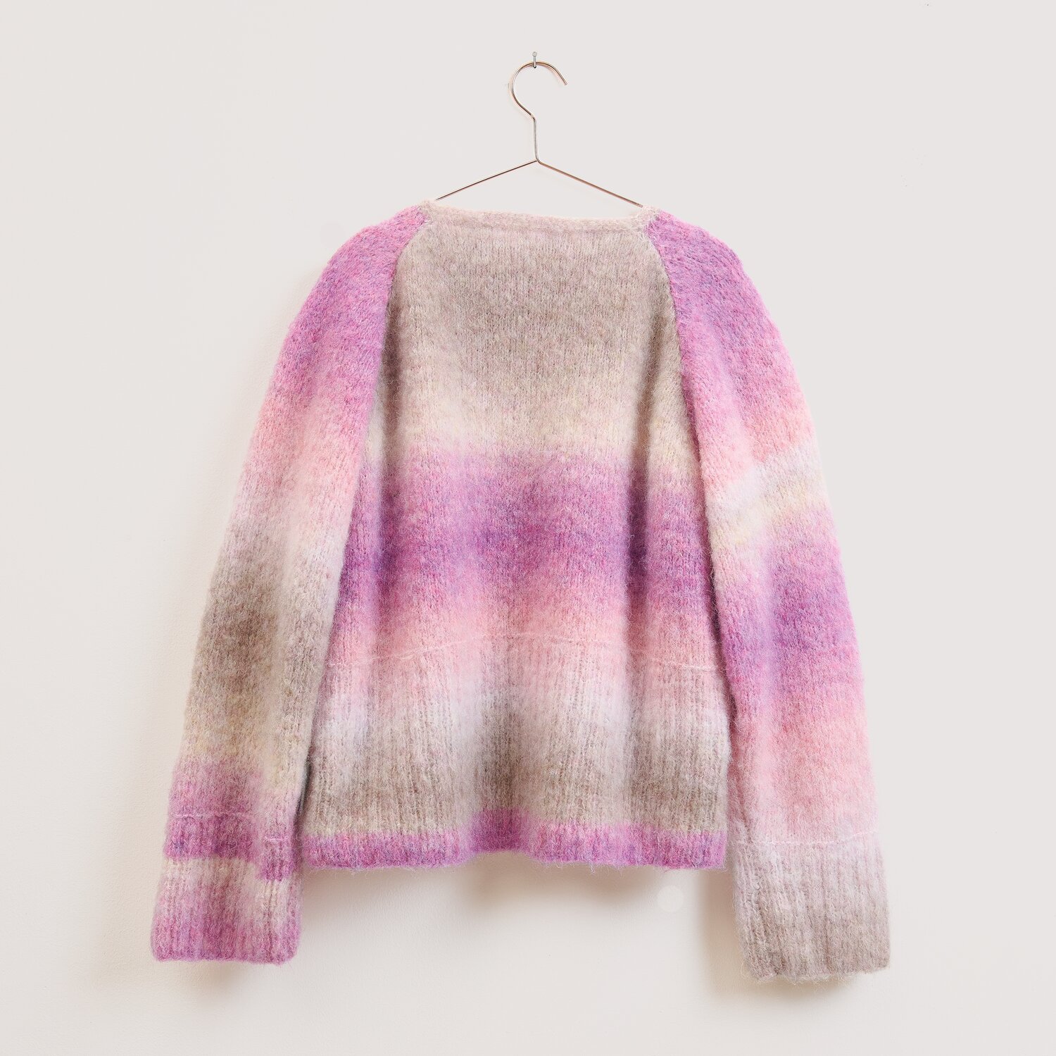 Die Neue Masche No. 16 Herbst, Strickpullover von Wolle Rödel mit weichem Farbverlauf in Beige, Rosa und Violett, locker geschnitten auf Metallbügel hängend