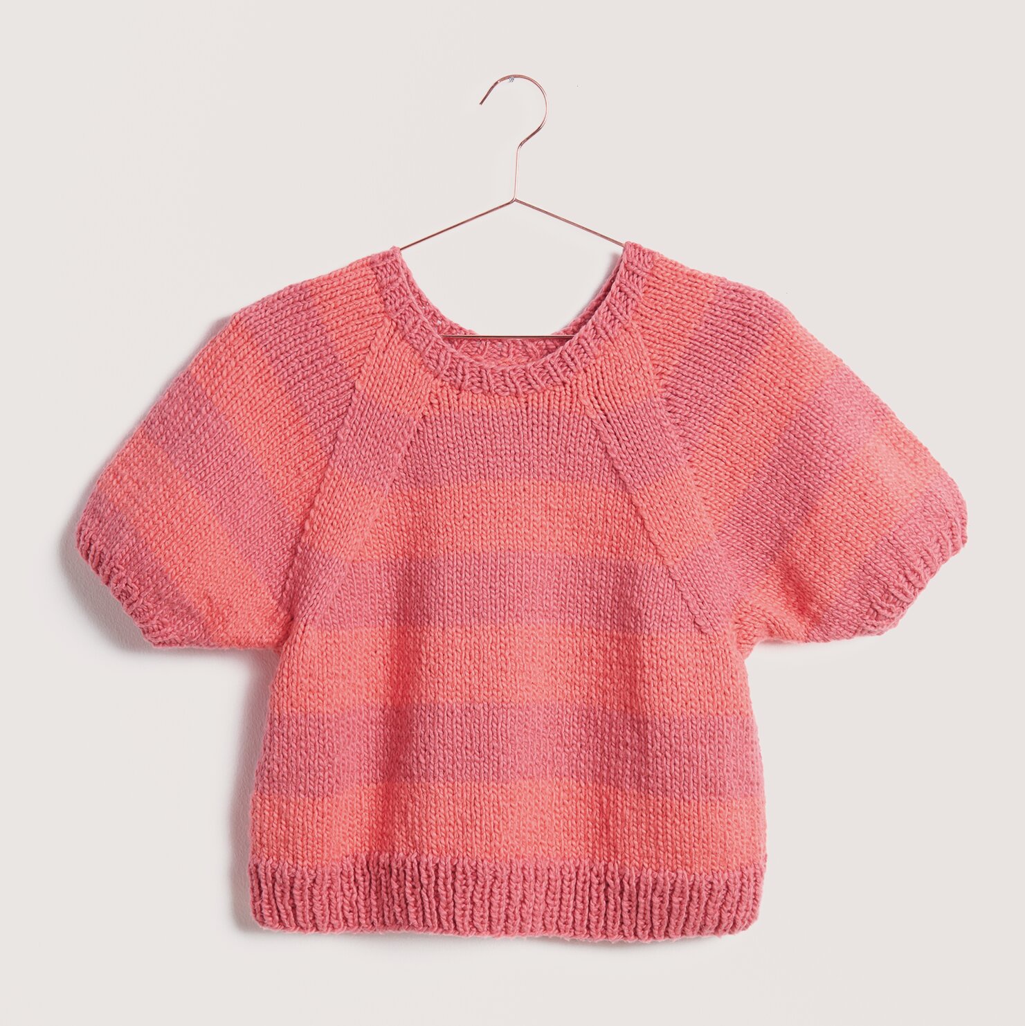 Strickset Shirt Modell 01 aus Die Neue Masche No. 9, rosa gestreift, auf einem Bügel präsentiert.