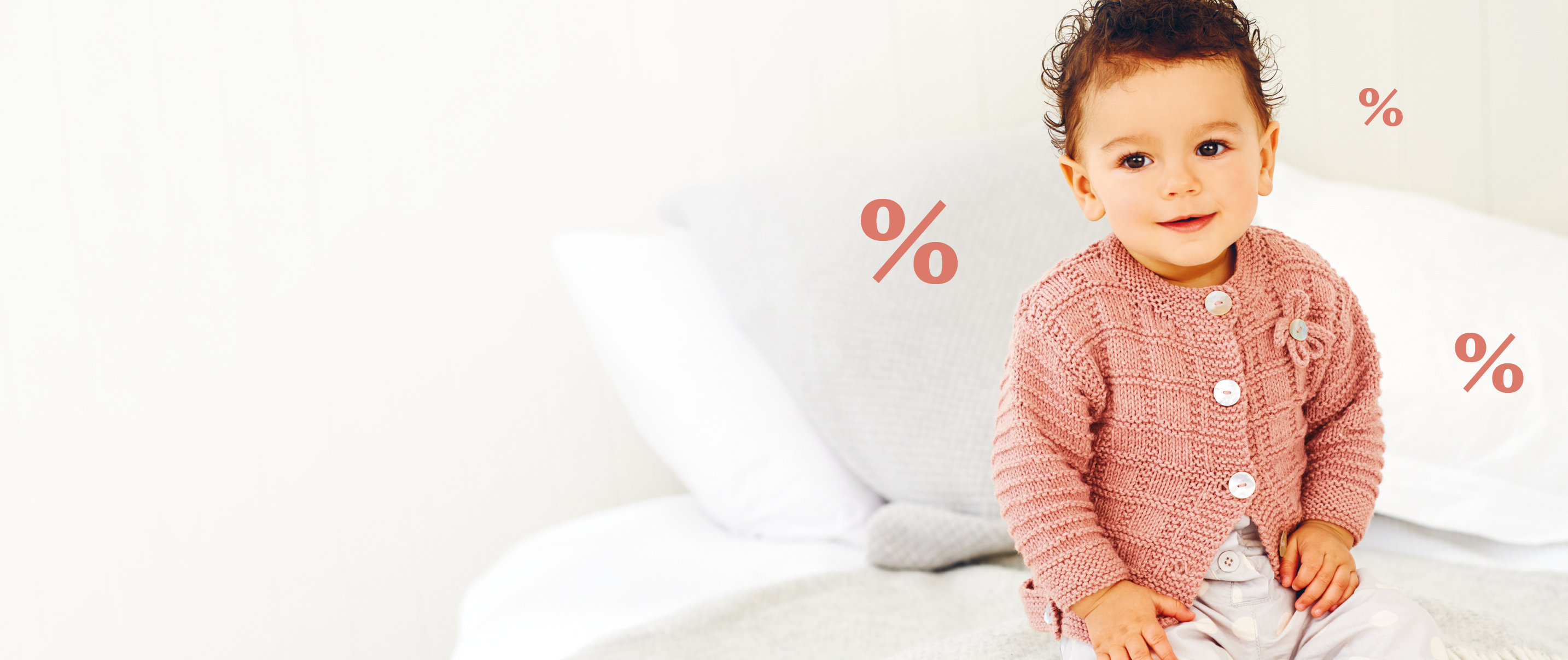 Baby trägt rosafarbene Strickjacke, im Hintergrund Prozentzeichen