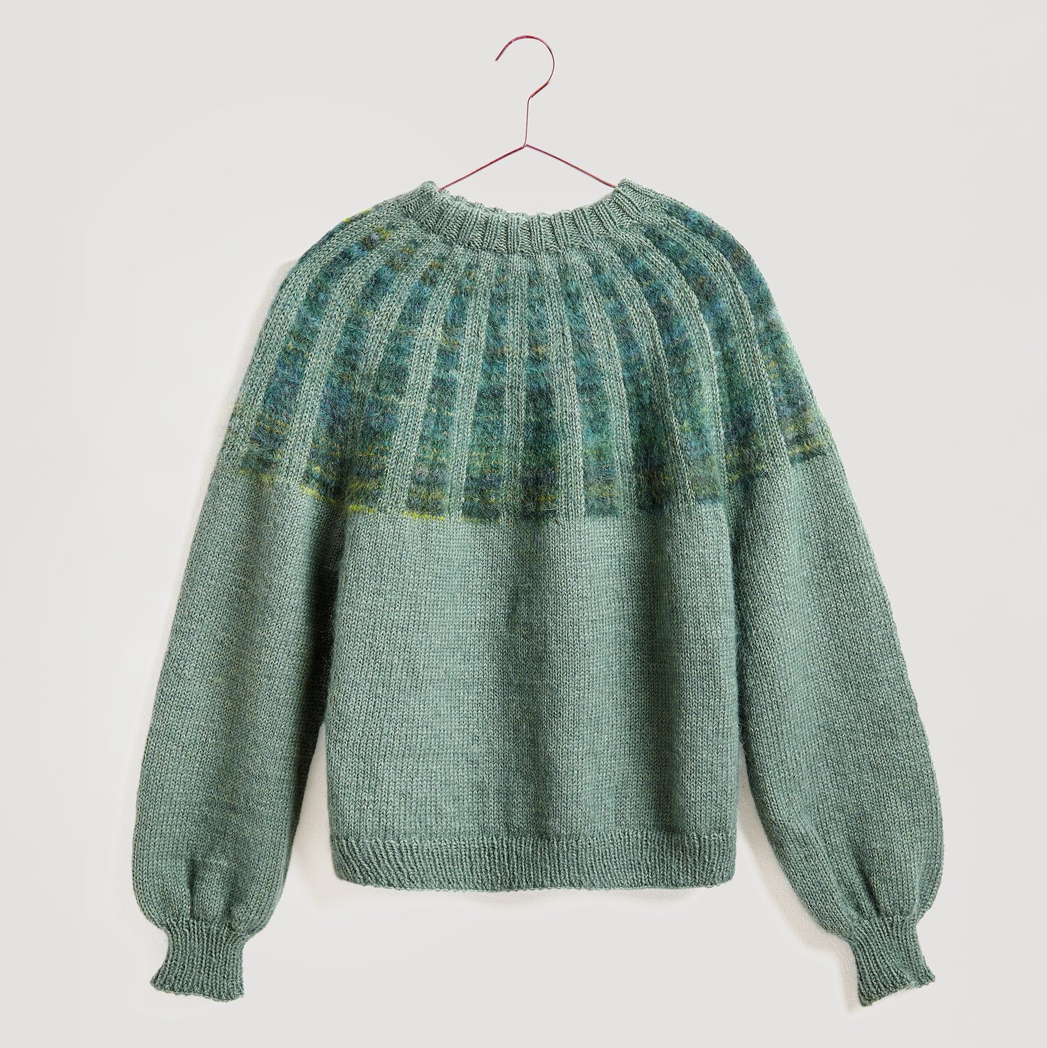 Die Neue Masche No. 13 Herbst von idee. Creativmarkt Strickset Pullover Modell 27 aus Die Neue Masche No. 13, gestrickt in sanftem Efeu-Grün.