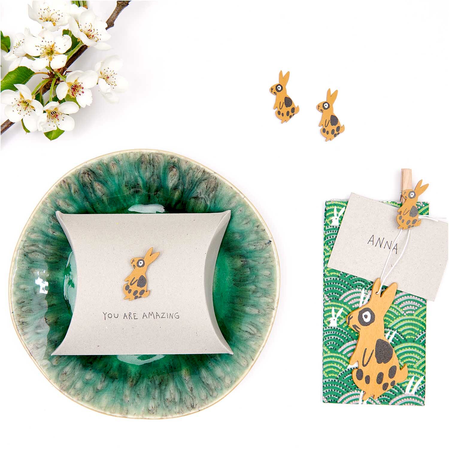 Holzsticker Hase gemustert 12 Stück: Braune Hasensticker auf grünem Teller und Geschenkverpackung.