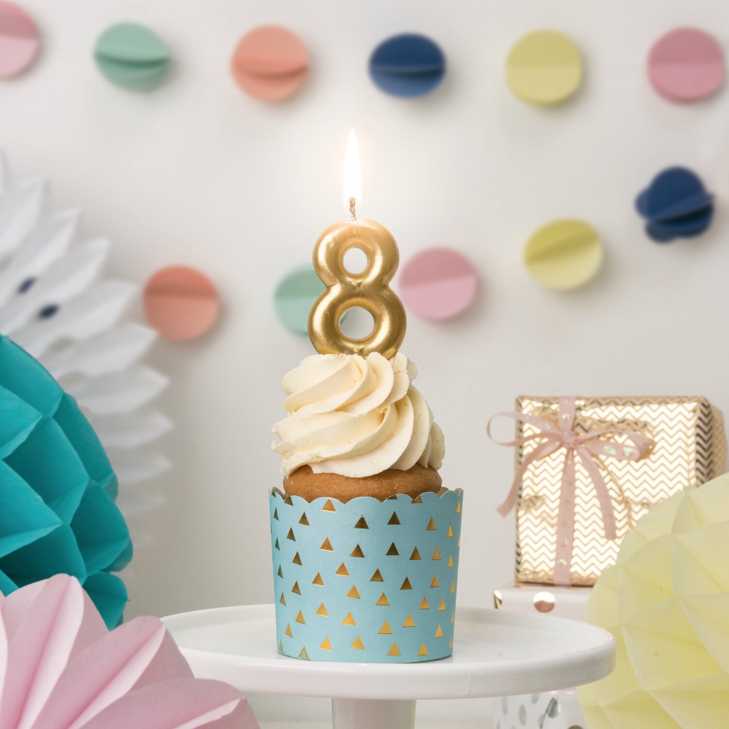 Zahlenkerze Gold auf Cupcake, festlich arrangiert mit Deko und Geschenkbox, ideale Partykerze von Rico Design für Geburtstag und Jubiläum.