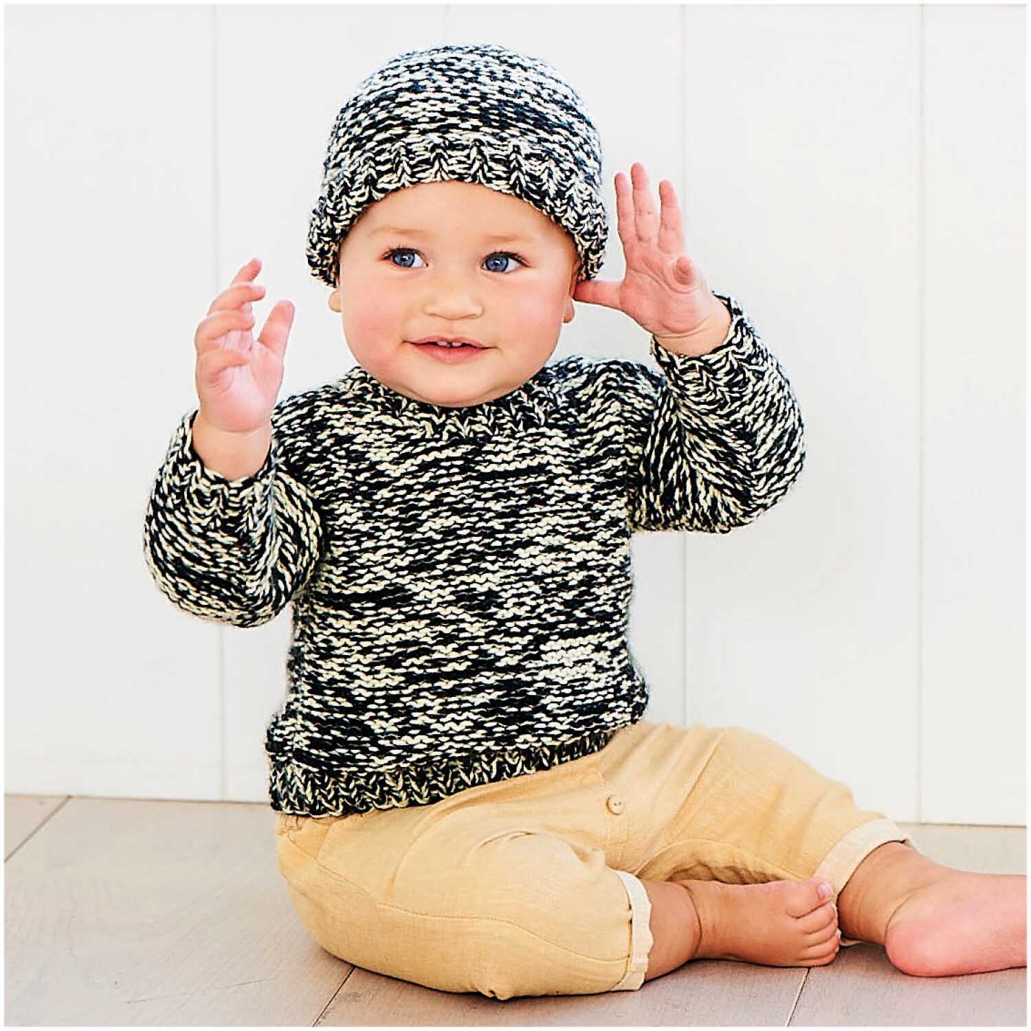 Rico Baby Dream dk uni - A Luxury Touch: Baby in gestricktem schwarz-weißem Outfit mit passender Mütze. Perfekt für stilvolle, gemütliche Momente.