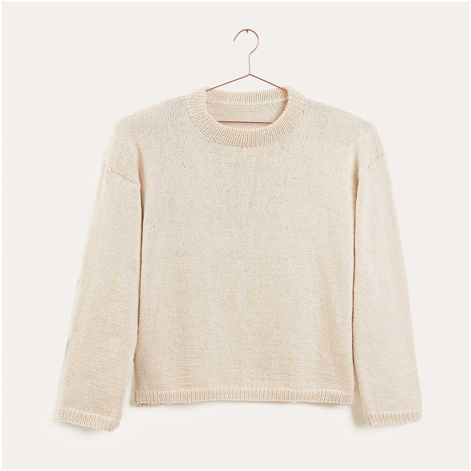 Strickset Pullover Modell 01 aus Luxury Knits: Cremefarbener Pullover auf einem Kleiderbügel vor neutralem Hintergrund.