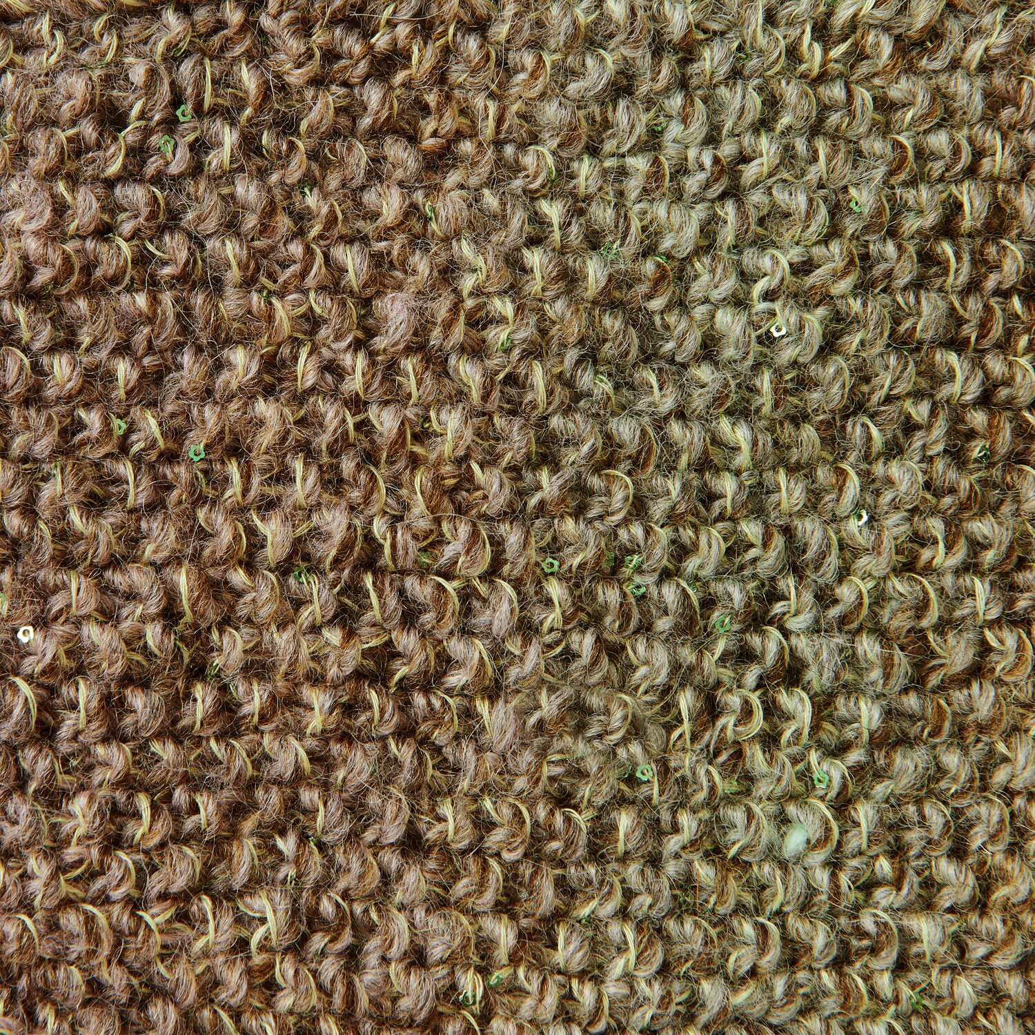 Lovewool No. 21 Herbst-Winter Sprachauswahl deutsch von Rico Design Nahaufnahme eines strukturierten, braunen Teppichs mit grober Webart. Die natürliche Farbgebung verleiht dem Raum eine warme Atmosphäre. Ideal für umweltbewusste Inneneinrichtungen.