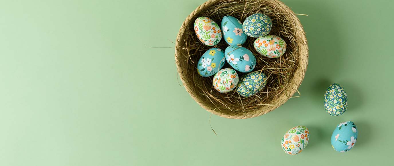 Bunte Ostereier liegen in Körbchen mit Ostergras