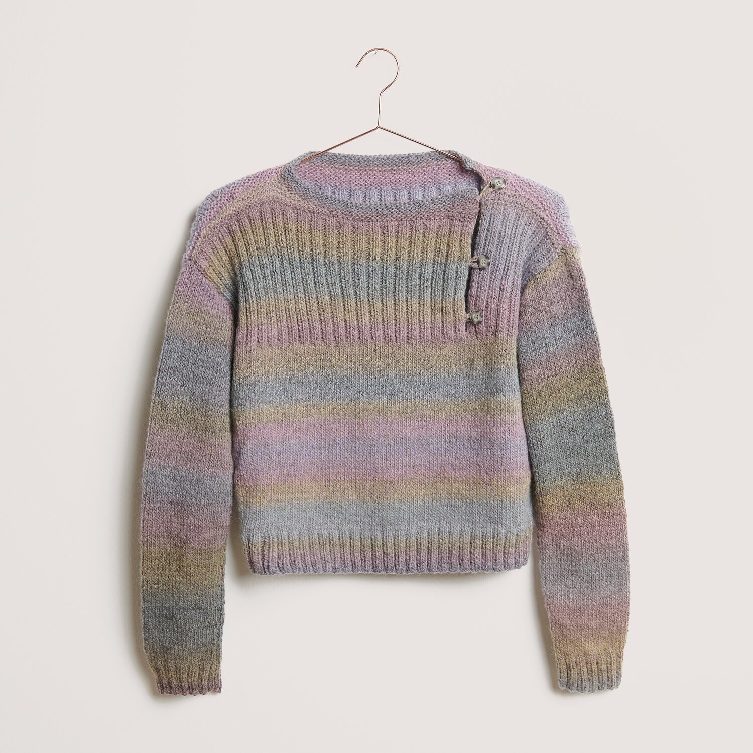 Creative Melange Alpaca Wonderball dk Pullover in Pastelltönen, gestrickt mit Rico Design Wolle, zeigt dezente Streifen und Knopfdetails auf der Schulter.