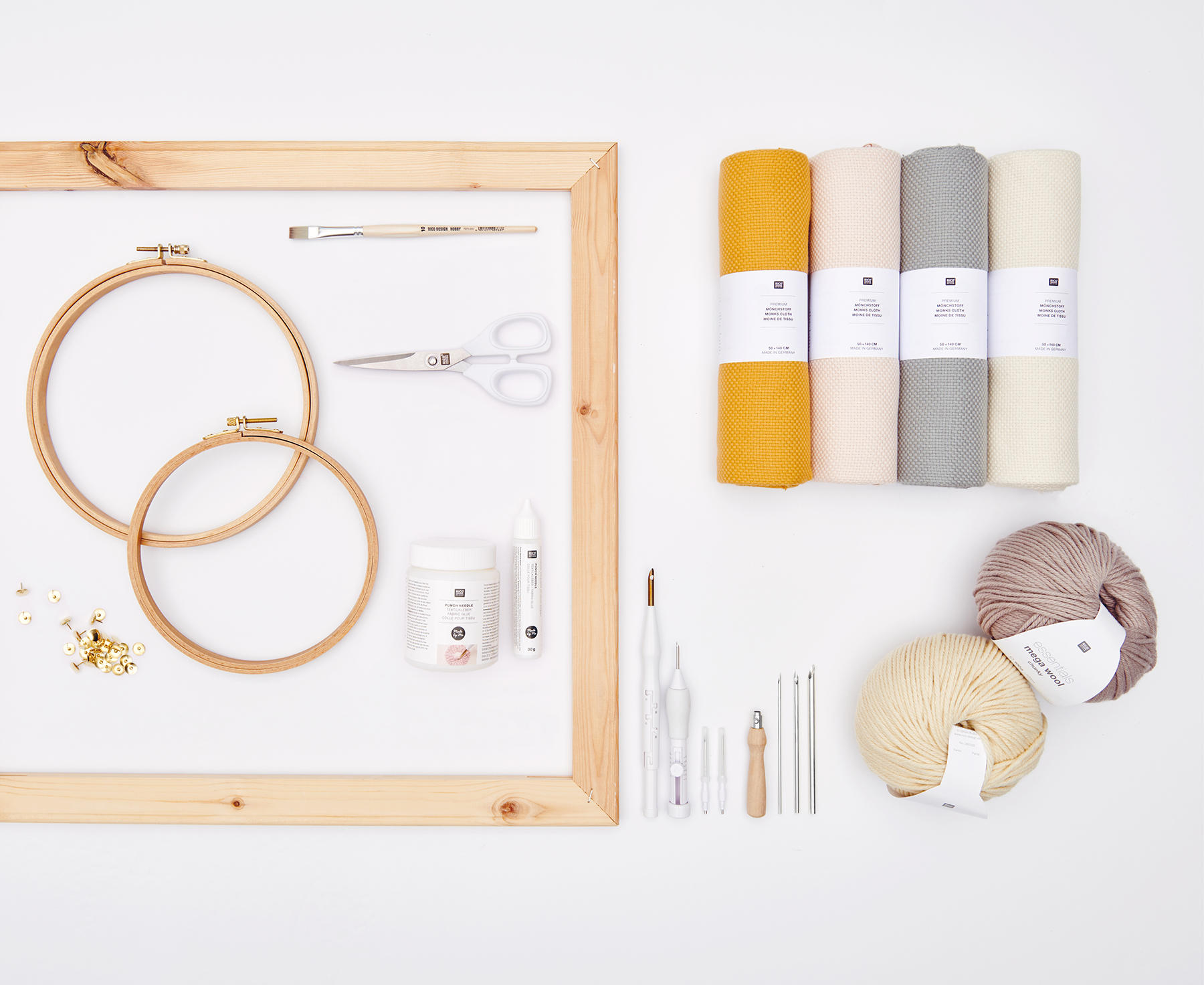 Punch Needle, Stickrahmen, Stoffrollen und Garn arrangiert auf grauem Hintergrund