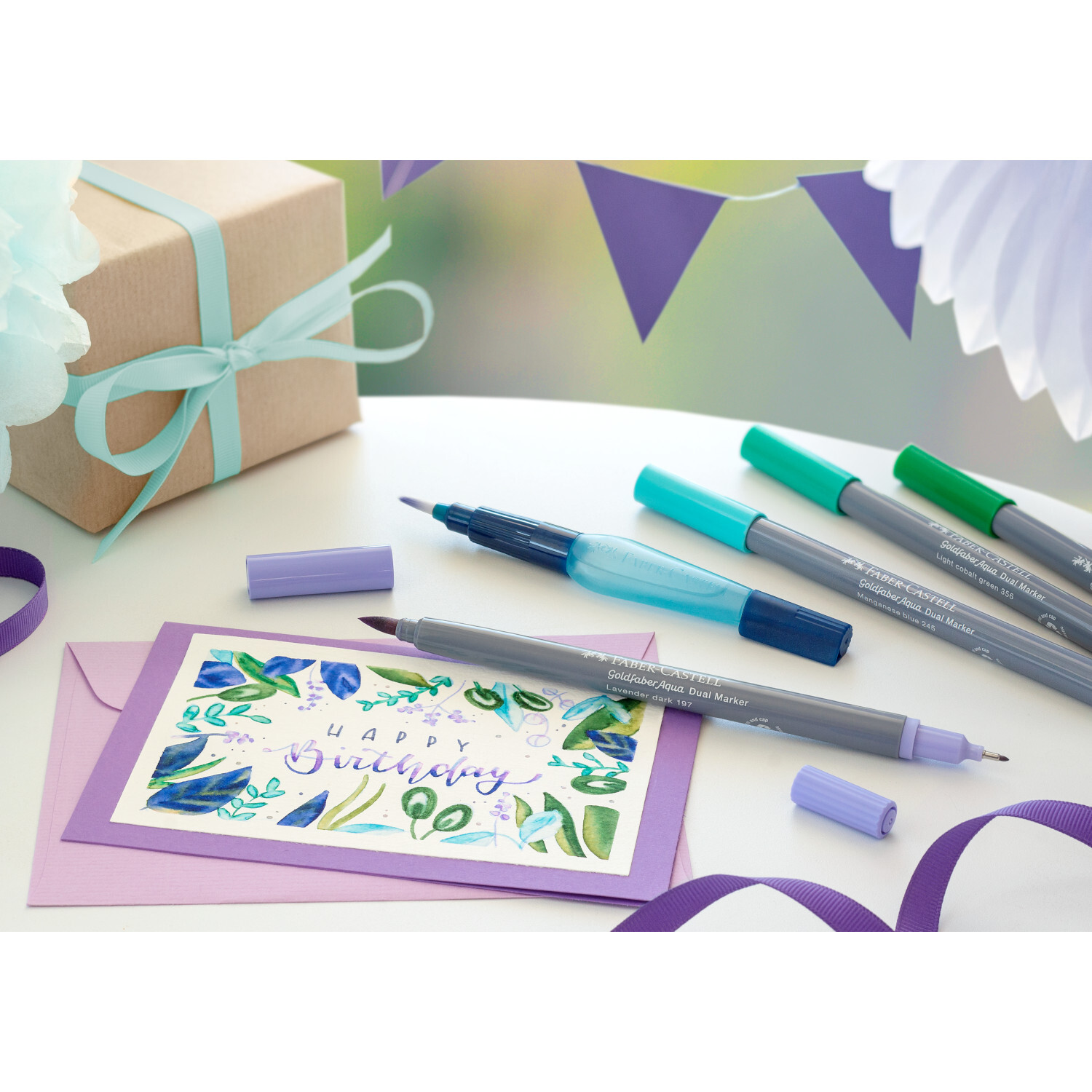 Goldfaber Aqua Dual Marker Farbe Schwarz von Faber-Castell Goldfaber Aqua Dual Marker auf einem Tisch mit Geburtstagskarte, Geschenk und Dekorationen. Ideal für kreative Projekte.