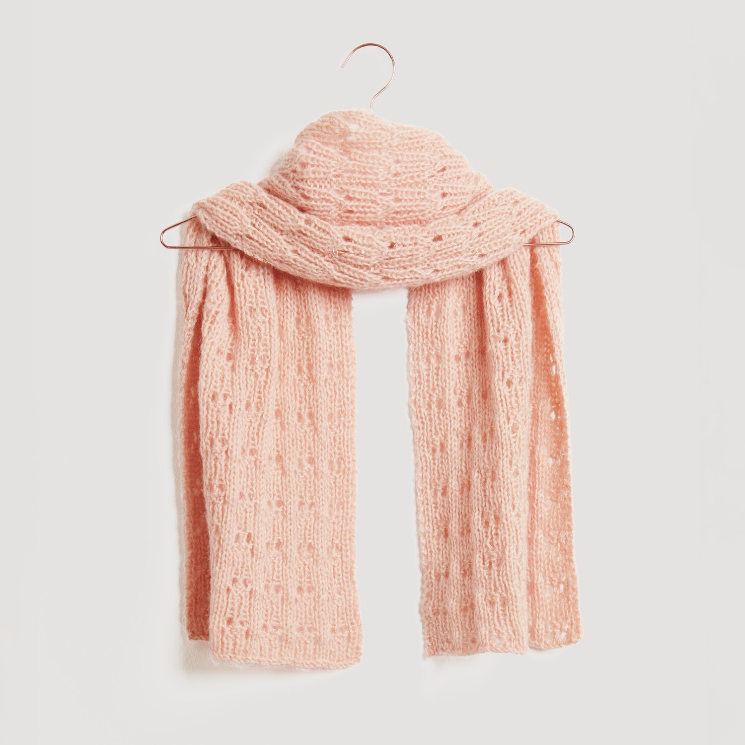 Lovewool No. 21 Herbst-Winter Sprachauswahl deutsch von Rico Design Ein weicher, rosa Strickschal hängt auf einem Kleiderbügel. Der Schal ist von der Marke Modell Legeware und besticht durch sein elegantes Design. Perfekt für kühle Tage.