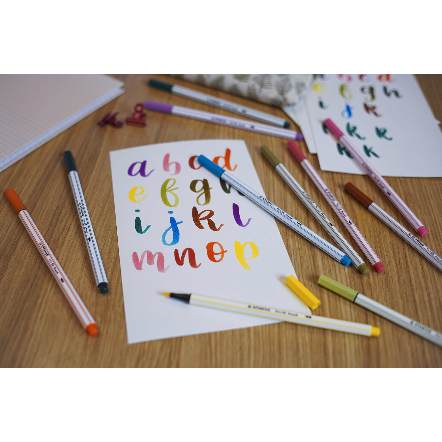 Pen 68 Brush im Kartonetui ohne Neonfarben 24 Farben: Bunte Stifte auf Holzoberfläche.