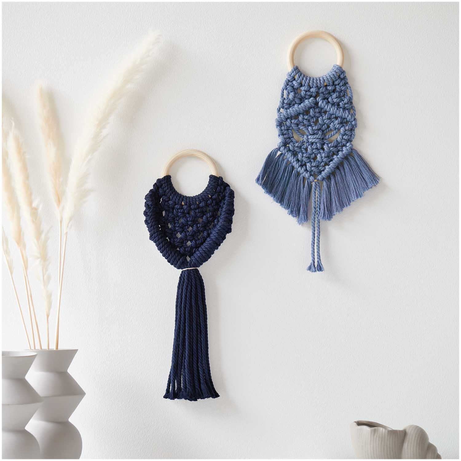 Creative Cotton Cord Makramee-Garn in Marineblau, dekorativ an der Wand als kunstvolle Makramee-Wandbehänge von Rico Design präsentiert.