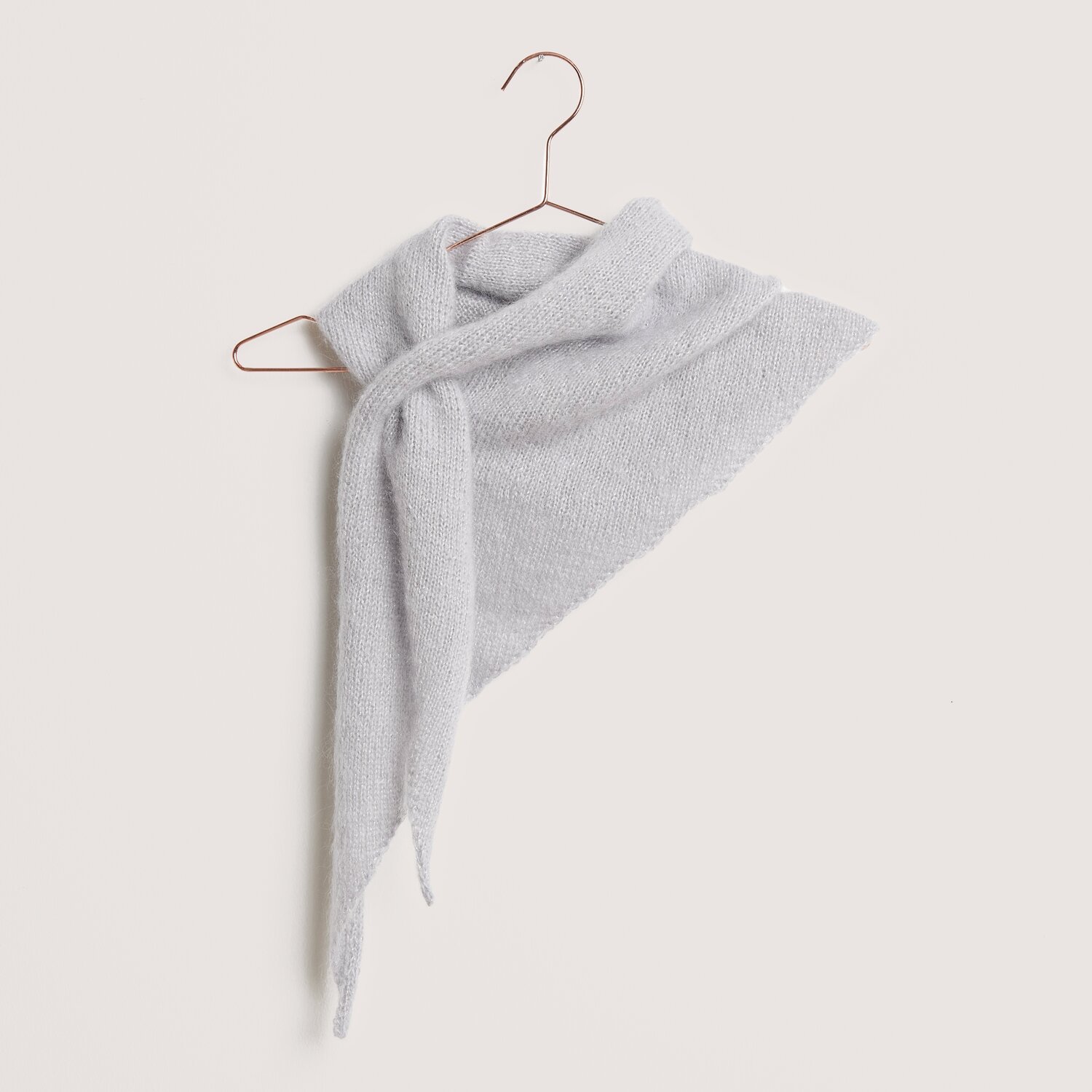 Die Neue Masche No. 14 Winter von idee. Creativmarkt Strickset Dreieckstuch Modell 23 aus DNM 14, hellgrau, elegant drapiert auf Kupferbügel.
