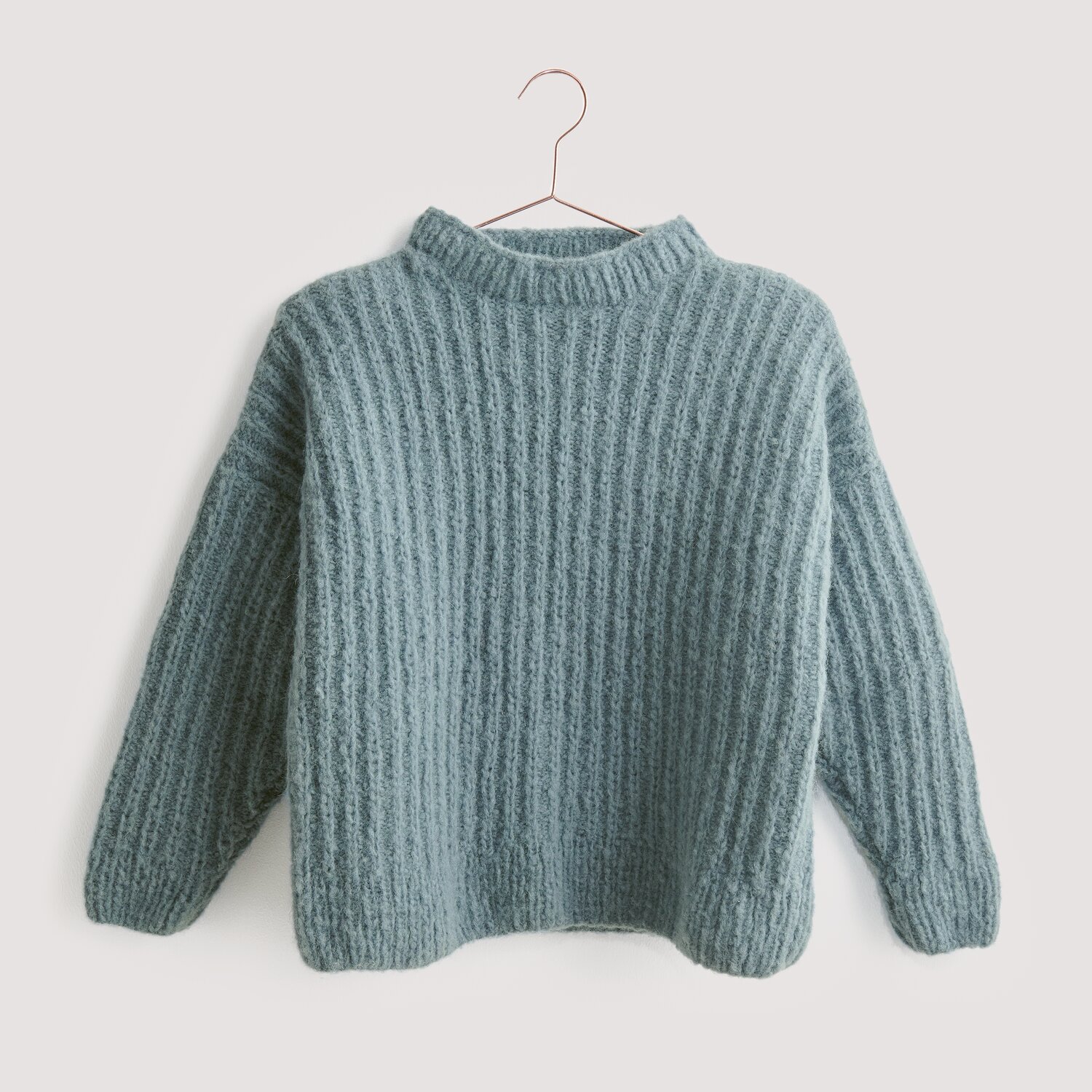 Strickset Pullover Modell 12 aus Luxury Knits, gestrickt in weichem Blau, präsentiert auf einem Kleiderbügel. Ideal für kühle Tage.