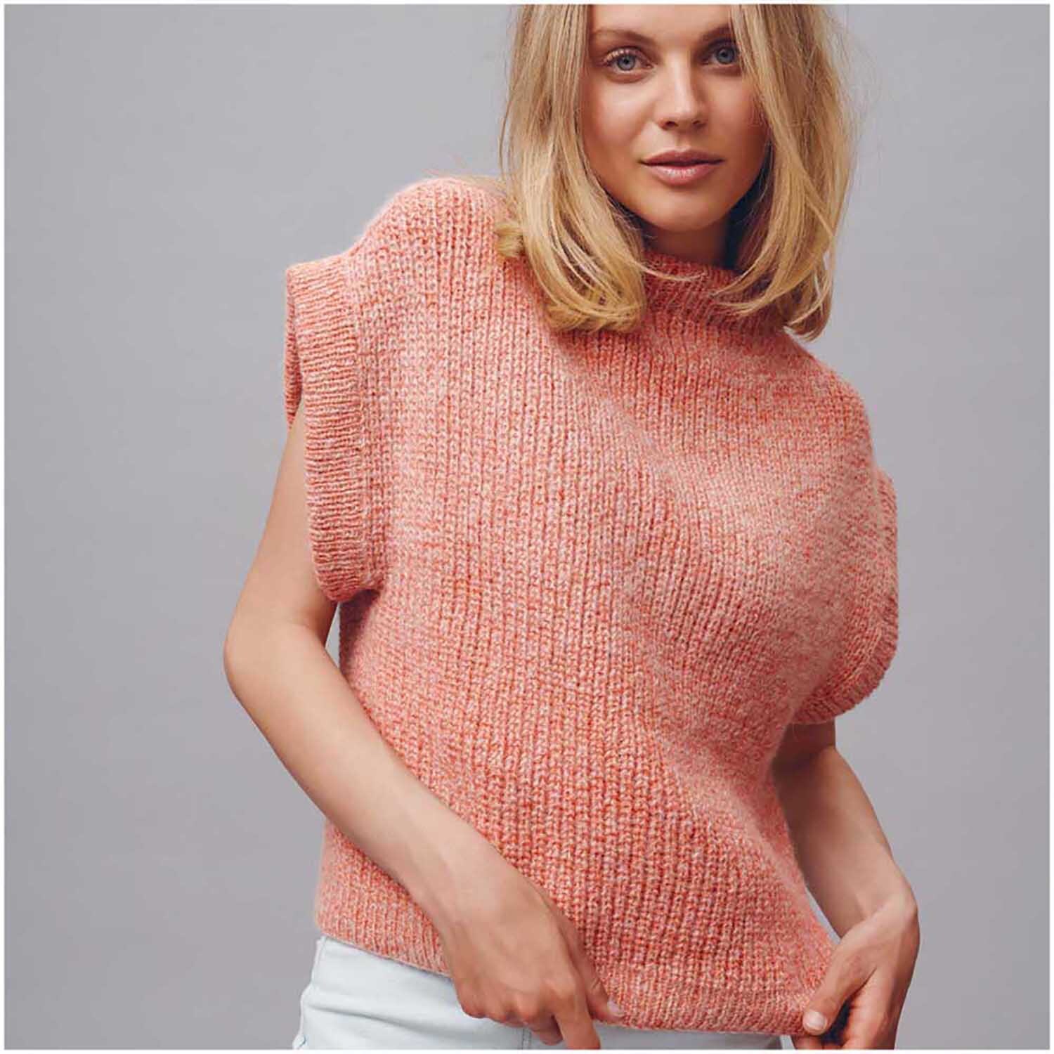 Strickset Pullunder Modell 07: Frau trägt korallenfarbenen Pullunder aus Top Down Knitting Special Nr. 2.