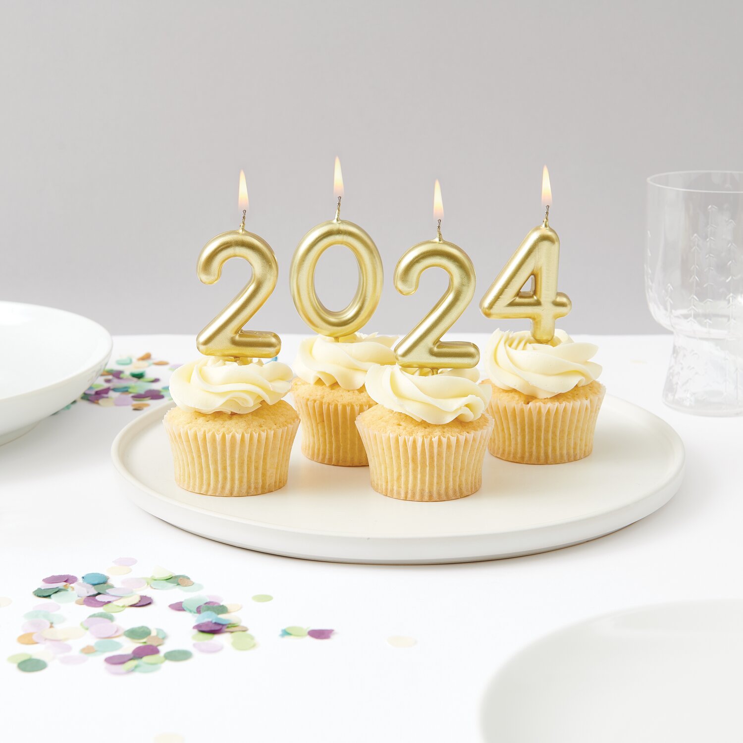 Zahlenkerze Gold von Rico Design, glänzende Kerzen in Form der Jahreszahl 2024 auf Cupcakes, stilvoll arrangiert für moderne Geburtstags- oder Silvesterdekoration