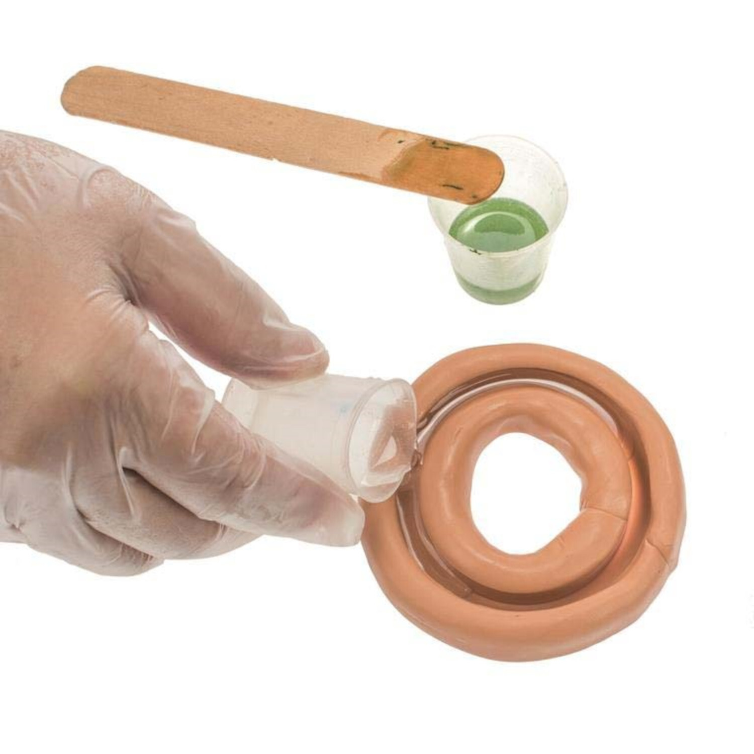 Crystal-Gießharz wird in eine runde Form gegossen. Ein Holzstab und ein kleiner Becher sind sichtbar.