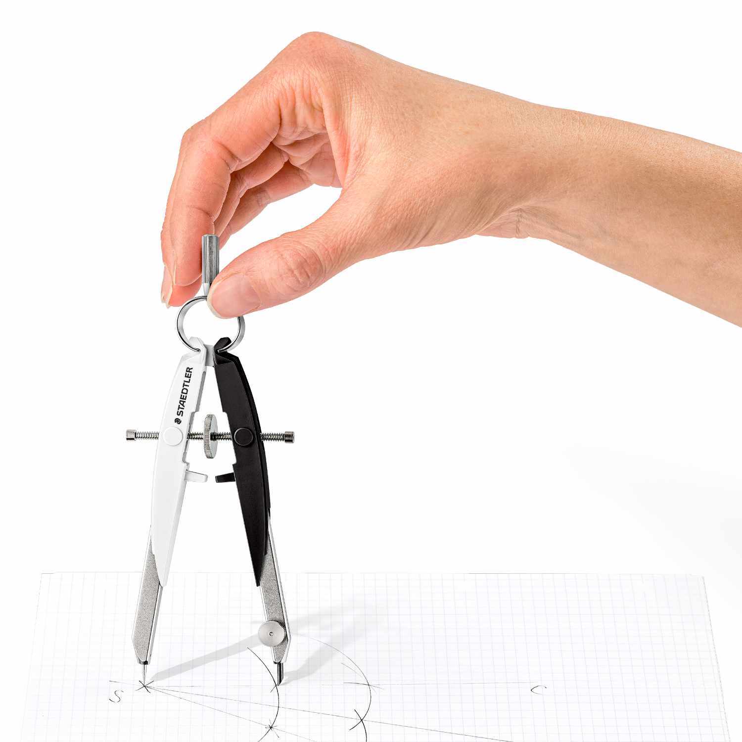 Mars Comfort Zirkel Farbe Schwarz-Weiß von STAEDTLER Mars Comfort Zirkel von Staedtler in Schwarz-Weiß wird von einer Hand über einem Papier gehalten.