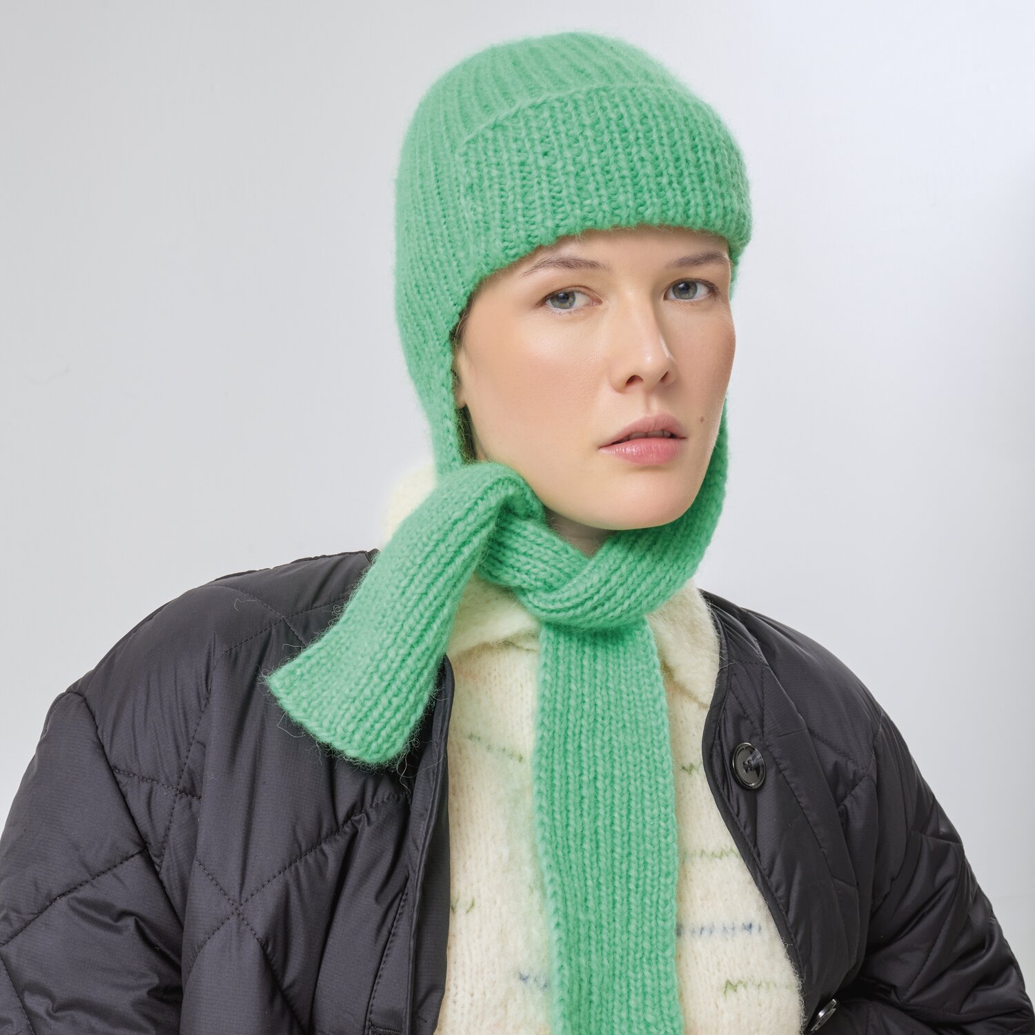 Strickset Mütze Modell 19 aus Made by Me No. 21 von Rico Design Strickset Mütze Modell 19 aus Made by Me No. 21: Frau trägt grüne Strickmütze und Schal.
