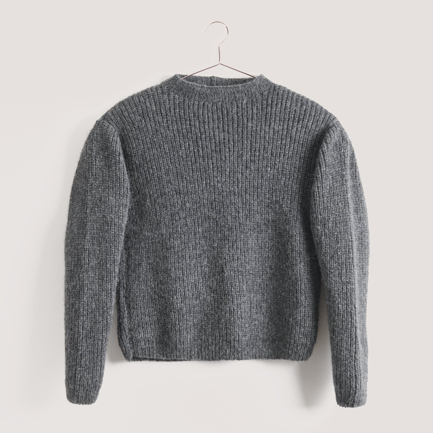 Made by Me Men No. 3 Sprachauswahl deutsch von Rico Design Strickset Pullover Modell 13 aus Made by Me Men No. 3 in Mittelgrau, gestrickt aus Rico Luxury Alpaca Superfine aran, präsentiert auf einem Kleiderbügel.