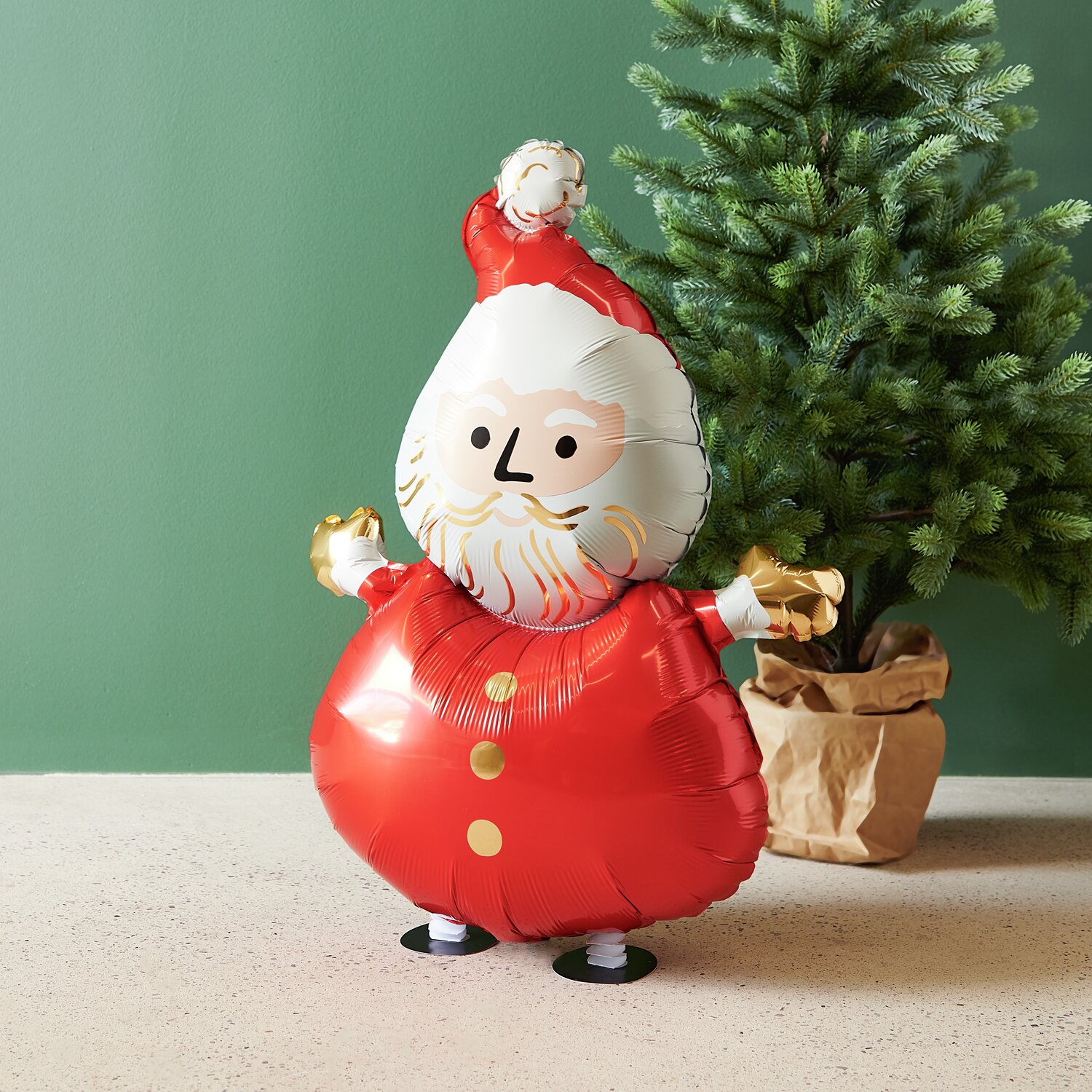 Folienballon Weihnachtsmann laufend: Roter Ballon in Form eines Weihnachtsmanns vor grünem Hintergrund.