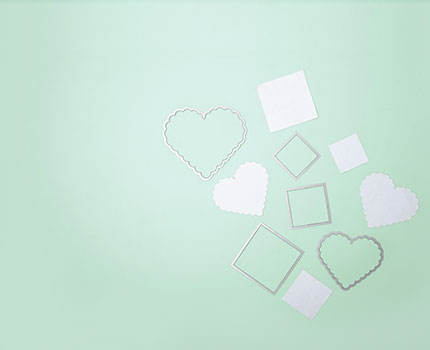 Framelits in Quadratformat und Herzform mit bereits ausgestanztem Papier in diesen Formen. Flatlay von Produkten.