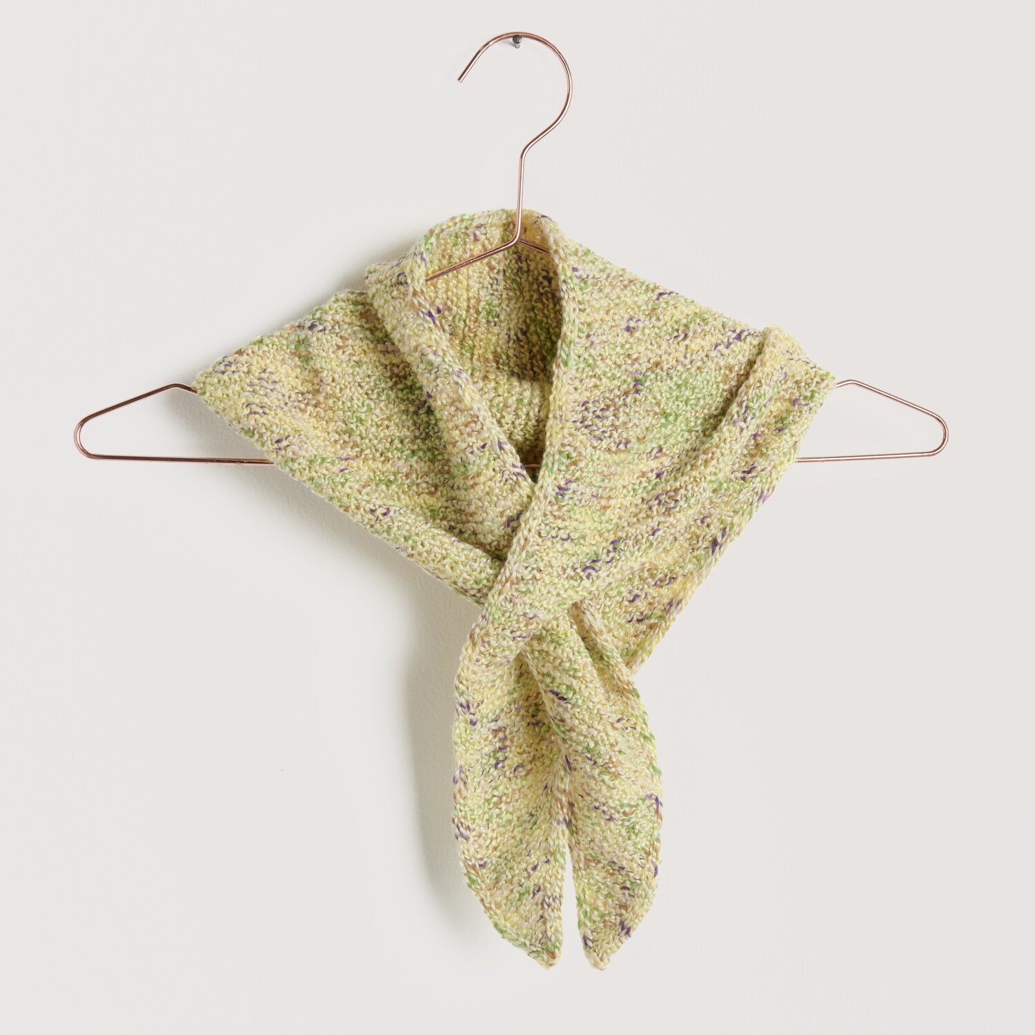 Strickset Minituch Modell 02 aus Lovewool No. 22 in zartem Gelbton, aufgehängt an einem Kupferbügel. Ideal für Frühling und Sommer.