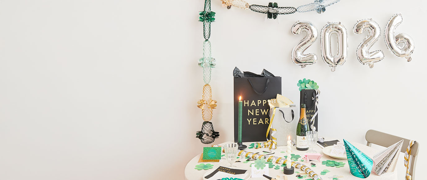 Tisch mit Silvester Partydeko, an der Wand hängt 2026 als Folienballon