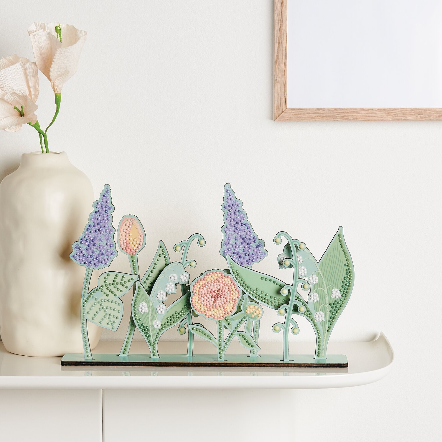 Diamond Painting DIY-Set Frühlingswiese zeigt bunte Blumen auf einem Regal, dekorativ arrangiert.