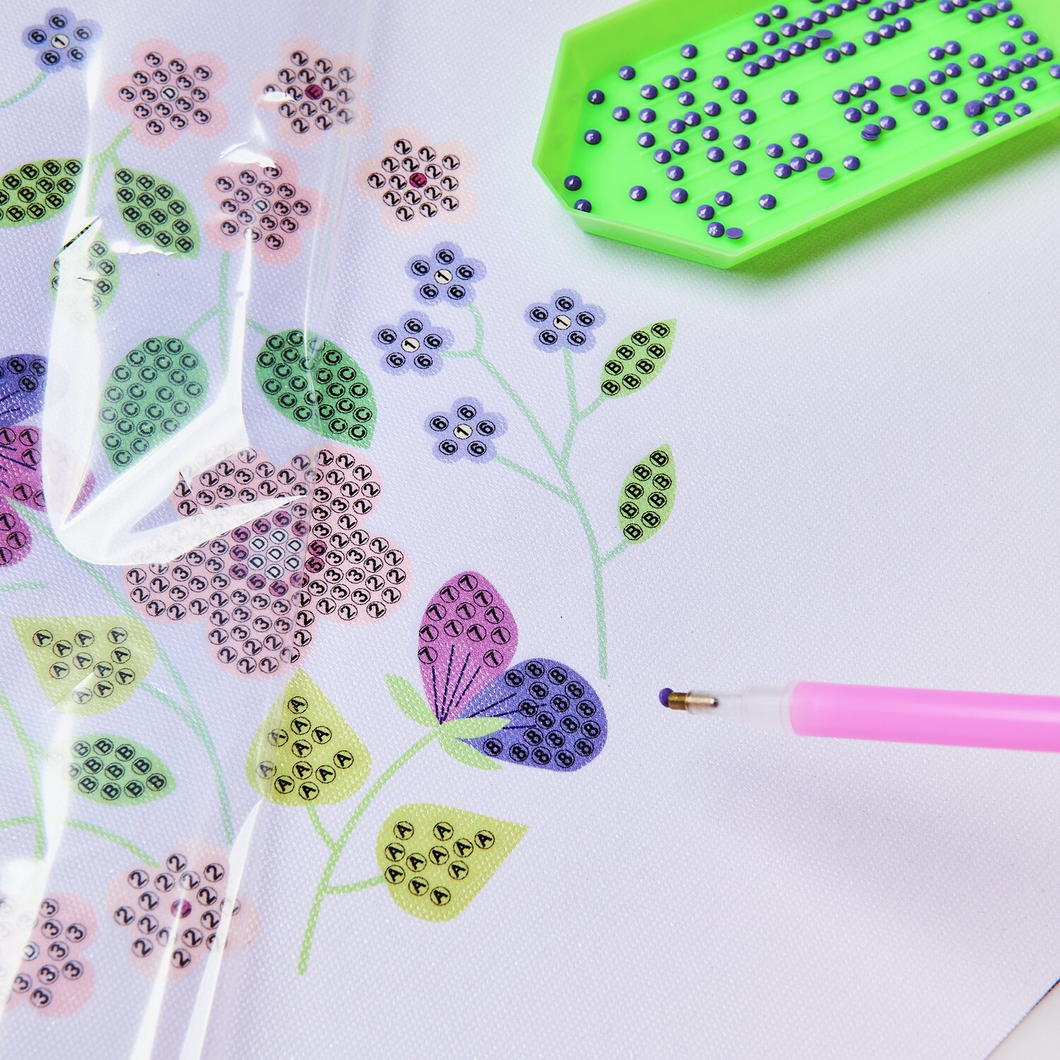 Diamond Painting DIY-Set Schimmernde Blumen 19-teilig zeigt bunte Blumenmuster mit Werkzeug.