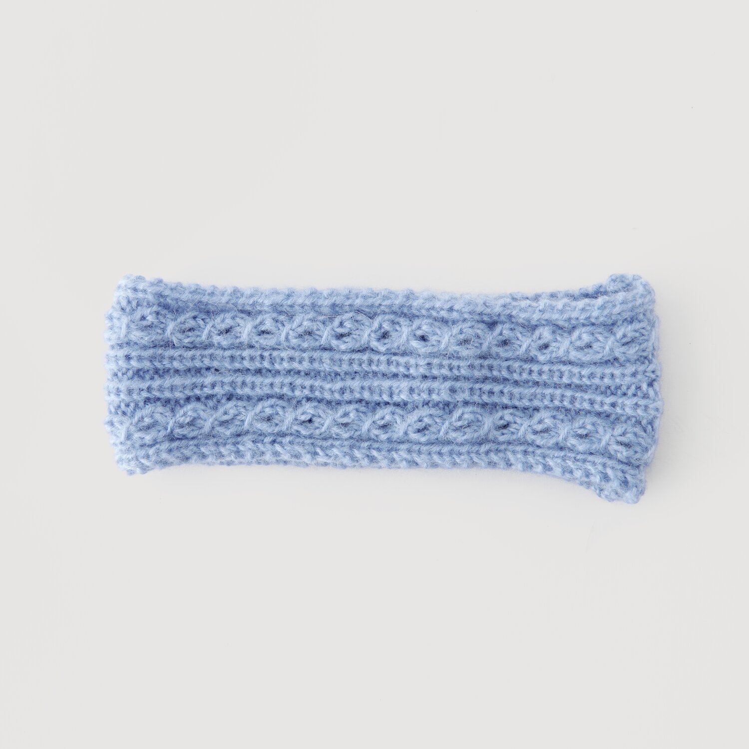 Lovewool No. 21 Herbst-Winter Sprachauswahl deutsch von Rico Design Stirnband aus hellblauer Wolle mit Zopfmuster, Modell Legeware. Ideal für kalte Tage, bietet es stilvollen Schutz. Perfekt für Modebewusste, die Komfort schätzen.